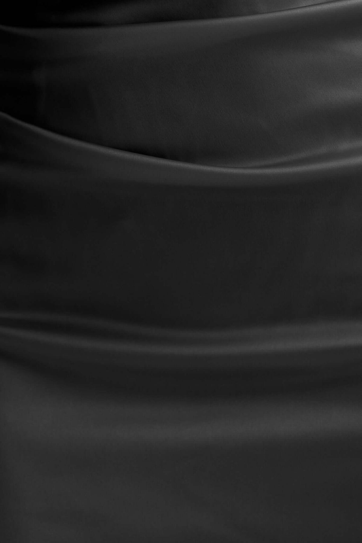 Close-up of the satin fabric of the Dimmi Maxi Dress in black, showcasing smooth texture and elegant draping.