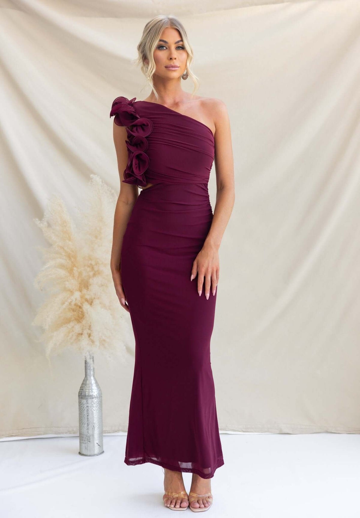 Meriden Maxi Dress in burgundy with one-shoulder neckline and floral detail, styled for special occasions.