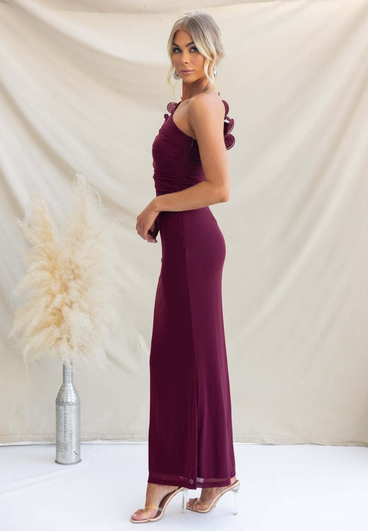 Model wearing a burgundy Meriden Maxi Dress with a one-shoulder neckline and side cut-out, showcasing a stylish fit.
