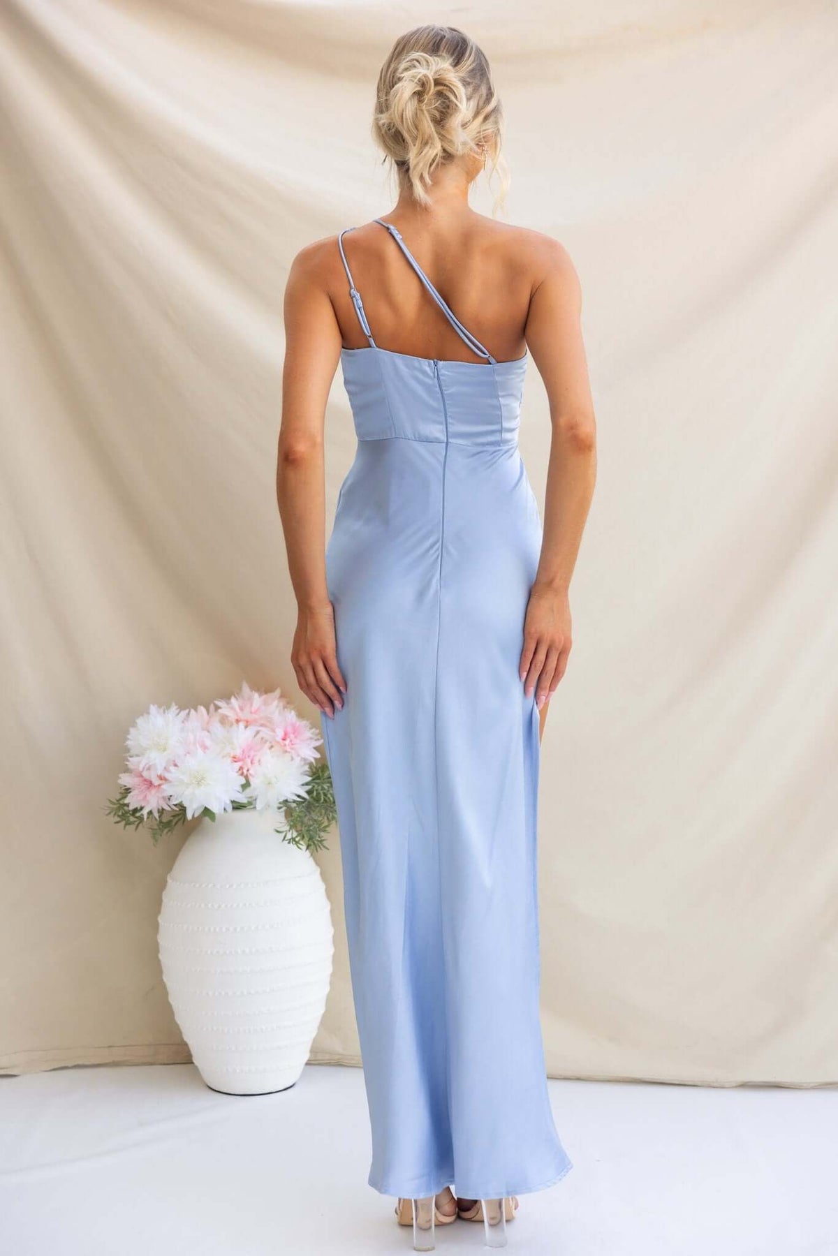 Back view of the Fahari Maxi Dress in light blue, featuring a one-shoulder design and sleek satin finish.