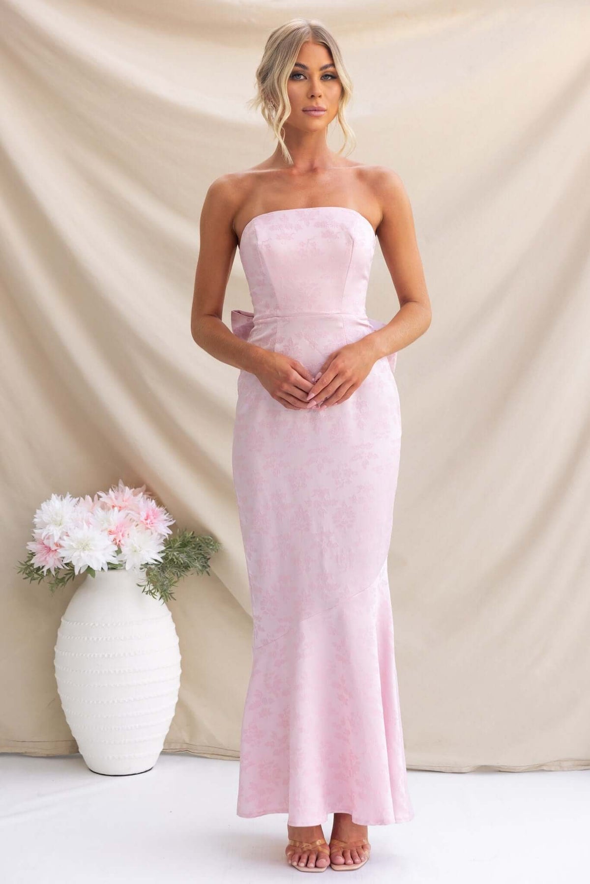Juanita Maxi Dress in light pink, strapless design with removable bow, perfect for weddings and special occasions.