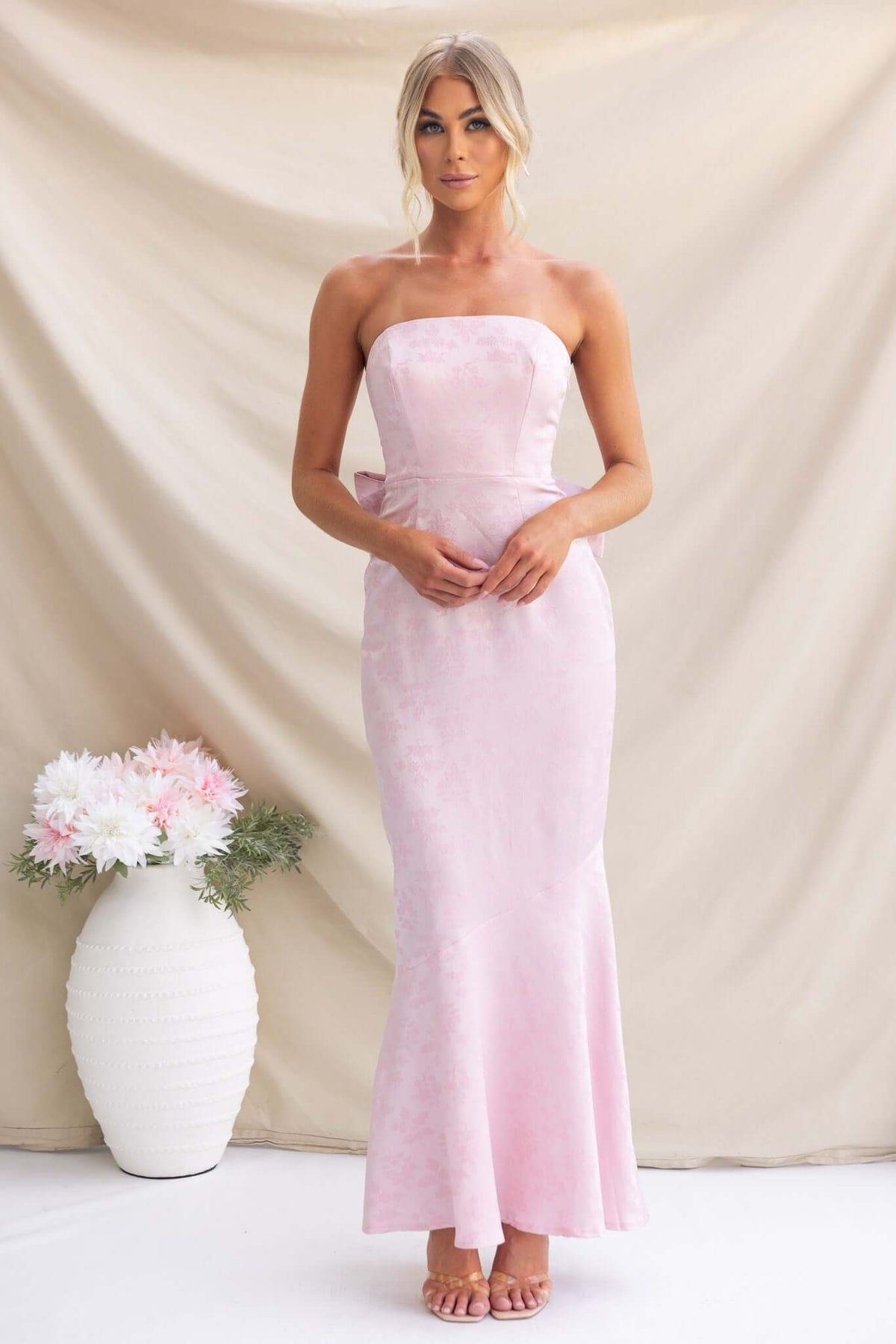 Juanita Maxi Dress in light pink, strapless design with removable bow, featuring a fitted silhouette and elegant style.