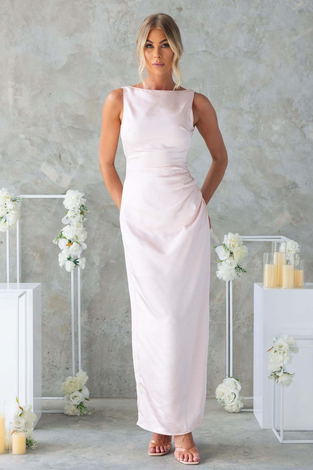 Elegant Dakari Maxi Dress in soft pink satin, featuring a high neckline and back split, styled for bridal occasions.