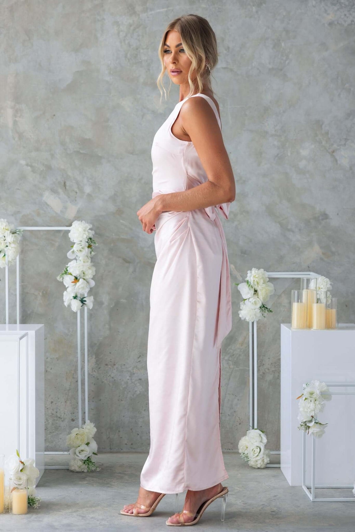 Model wearing the Dakari Maxi Dress in soft pink, showcasing the satin finish and elegant design, perfect for special occasions.