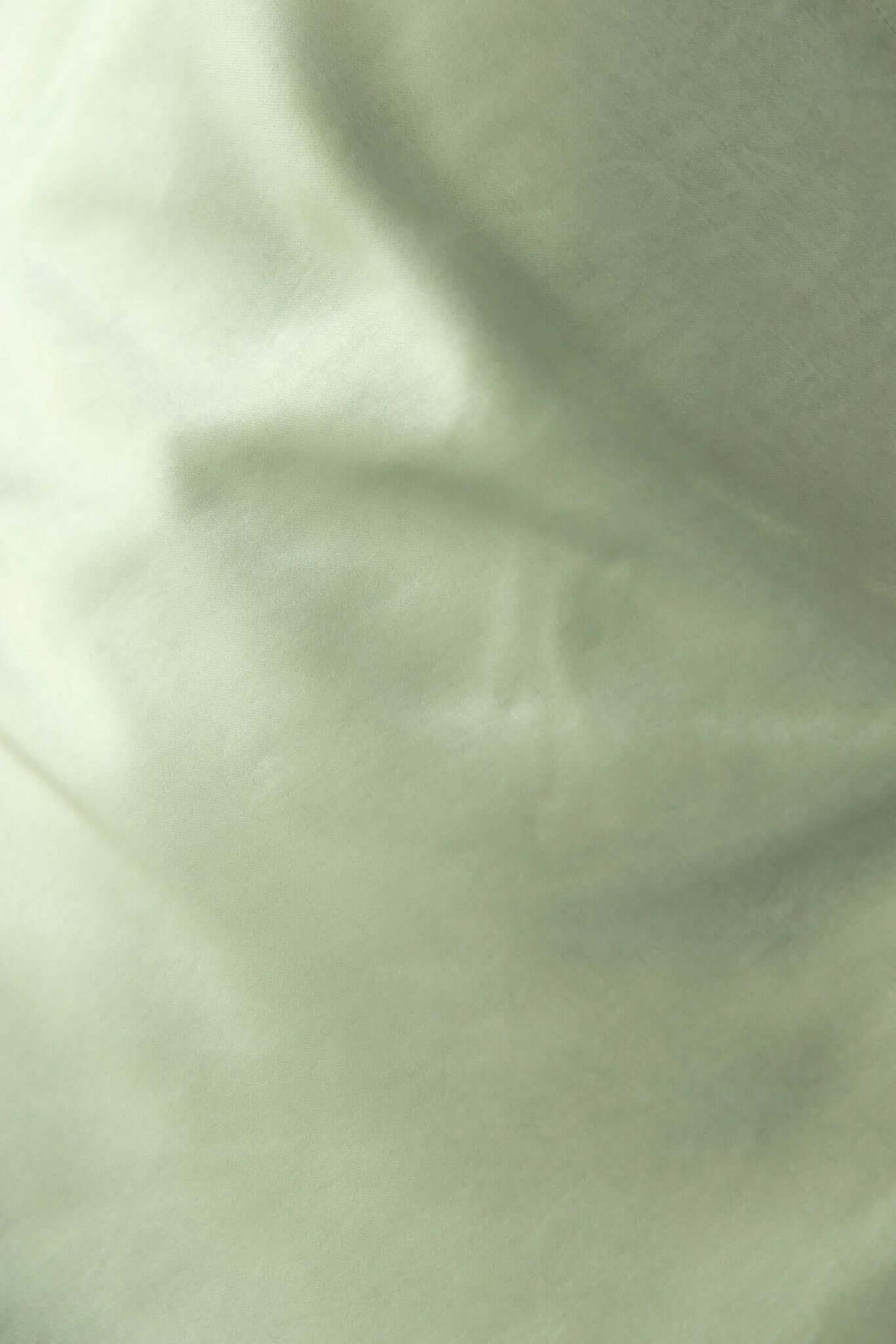 Close-up of soft, smooth green fabric perfect for draping in apparel like dresses.