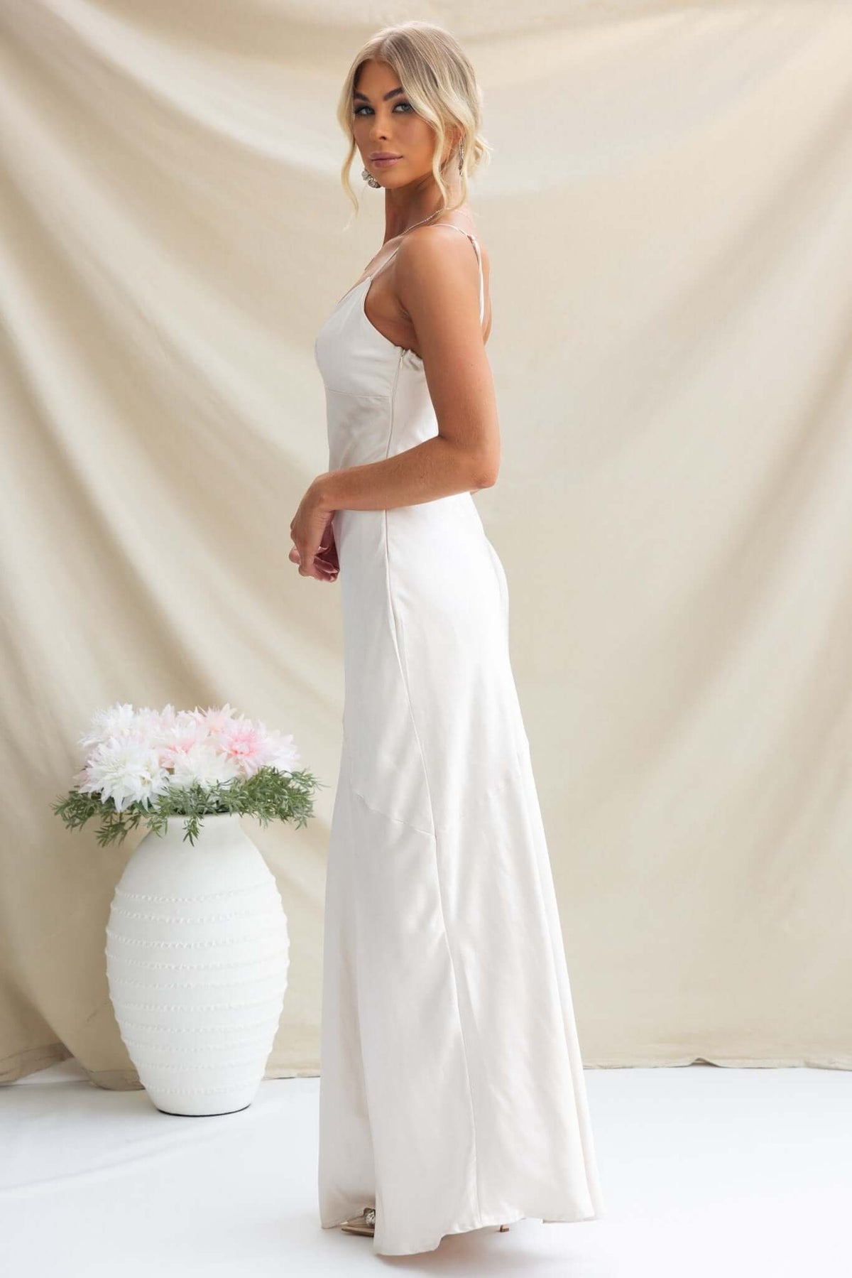 Elegant Coralina Maxi Dress with adjustable straps in satin material, shown from the side against a neutral backdrop.