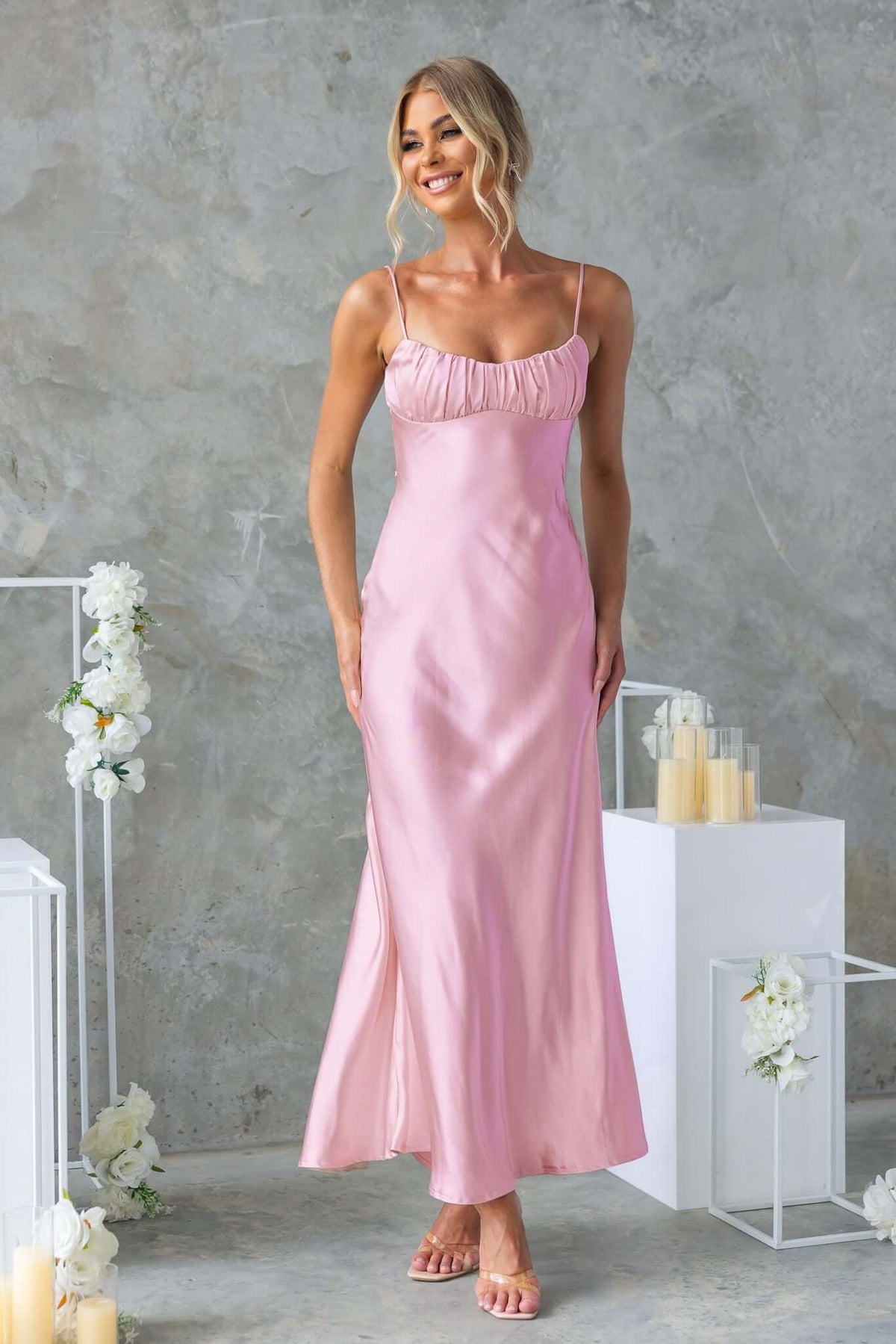 Maeya Maxi Dress in soft pink satin with adjustable straps and gathered bust detail, styled for a bridal look.