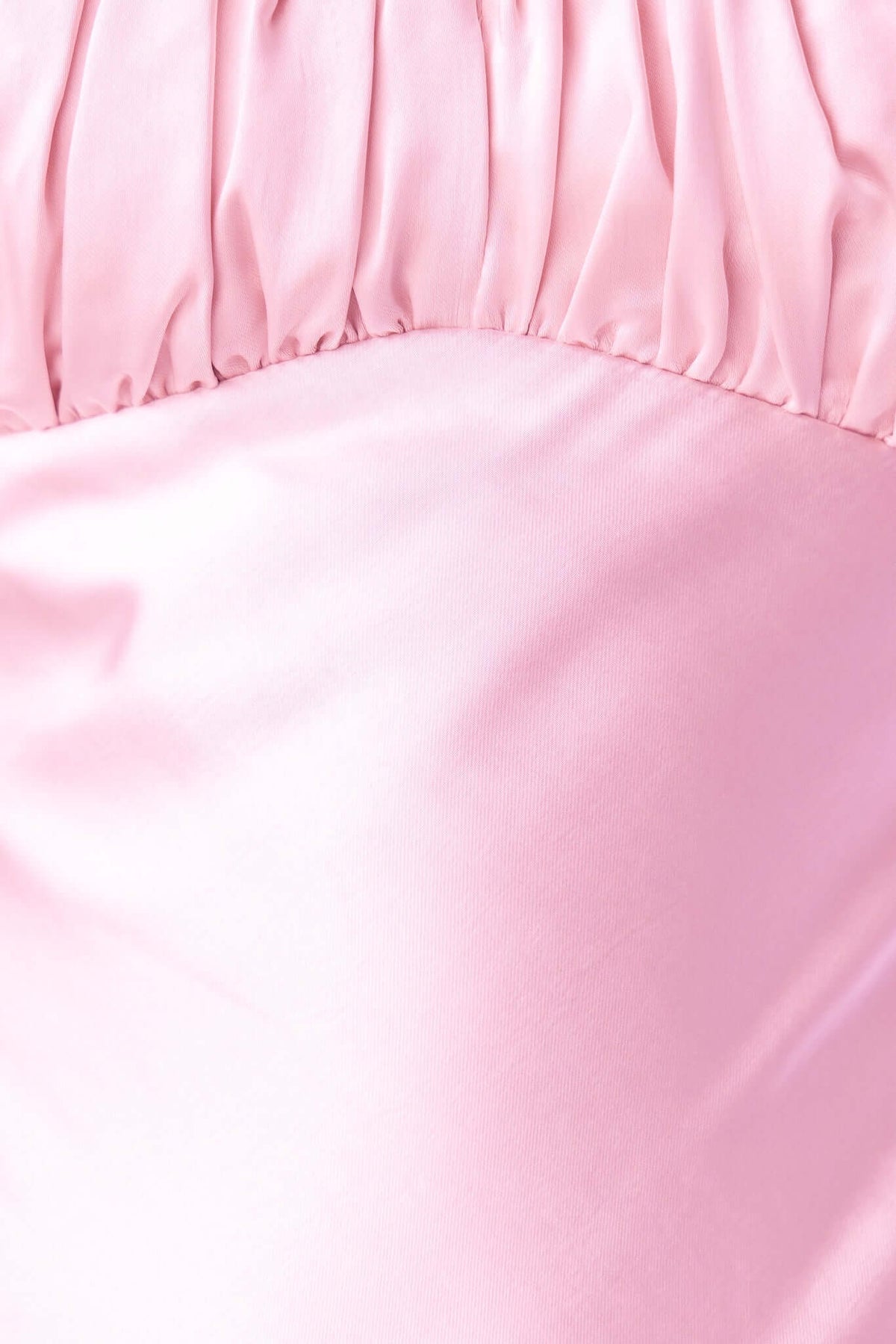 Close-up of soft pink satin fabric with gathered detailing, showcasing the elegant material of the Maeya Maxi Dress.