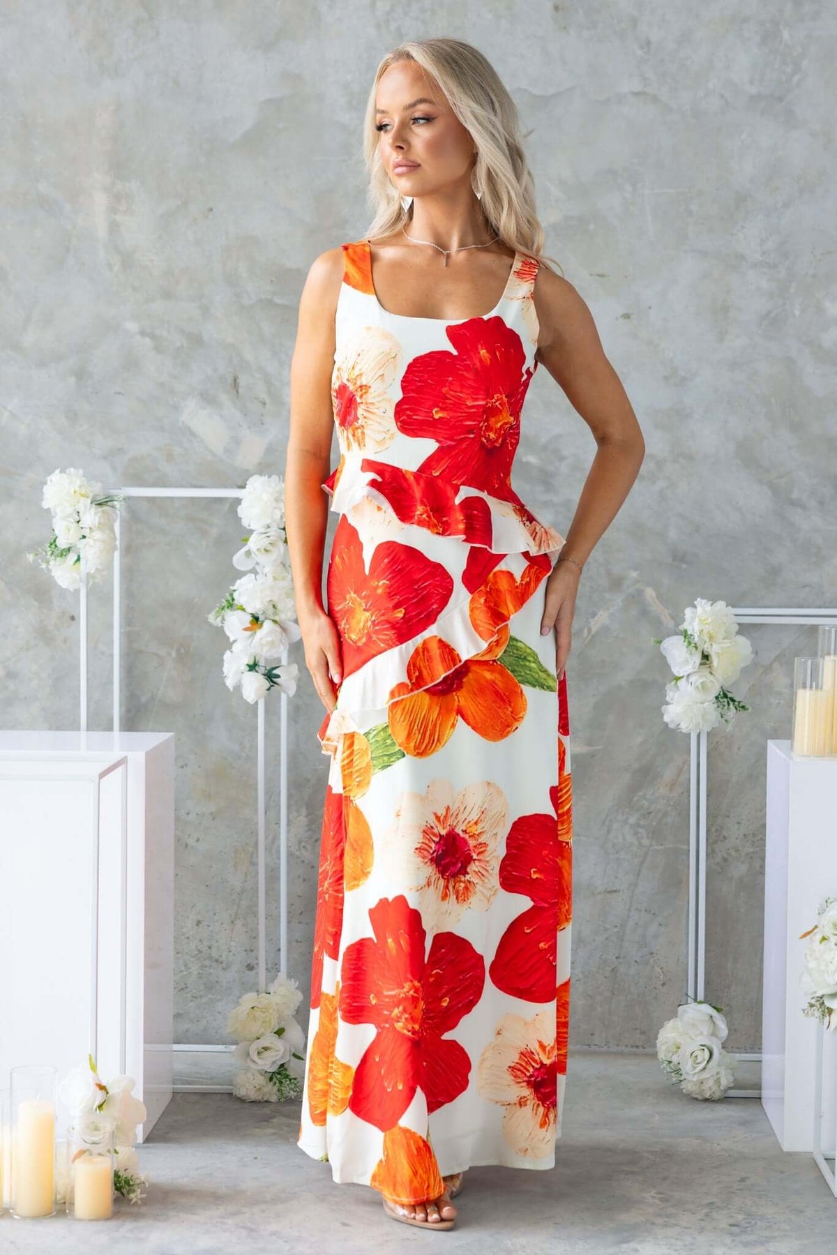 Model wearing Larni Maxi Dress with vibrant red and orange floral print, perfect for summer occasions.