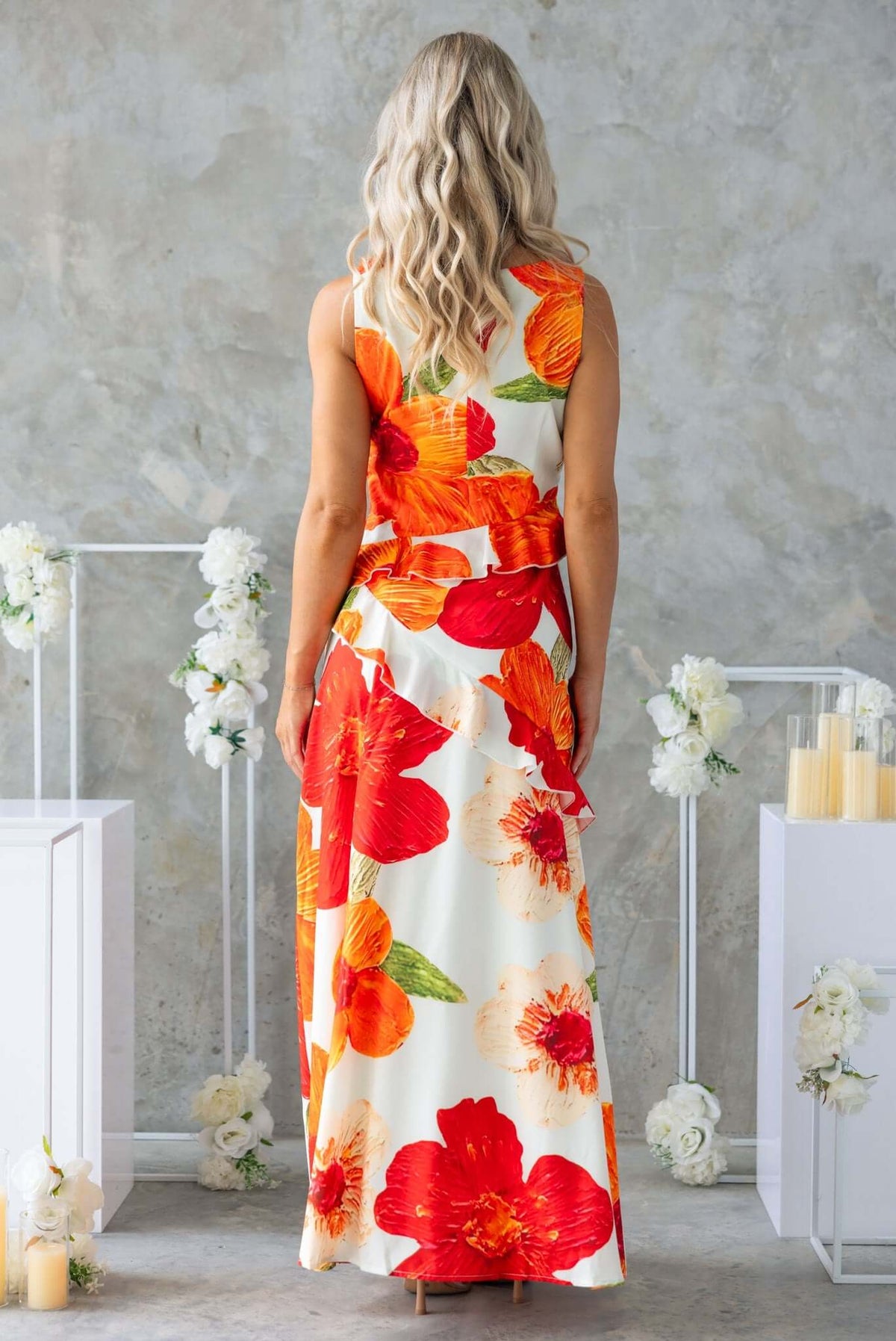 Back view of a woman in a colorful floral Larni Maxi Dress against a neutral backdrop.