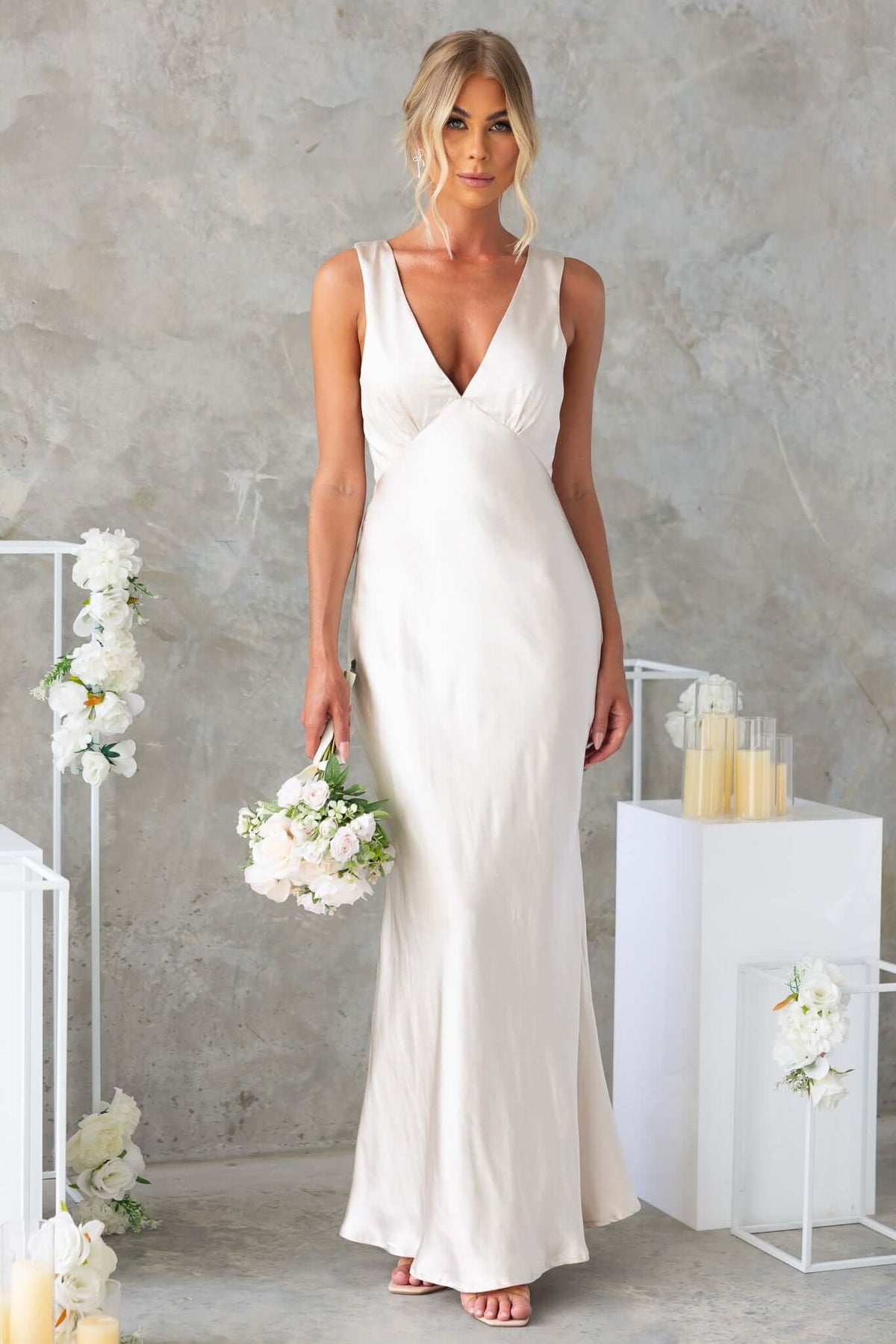 Darina Maxi Dress in satin with V-neckline, featured on model holding flowers, ideal for bridal occasions.