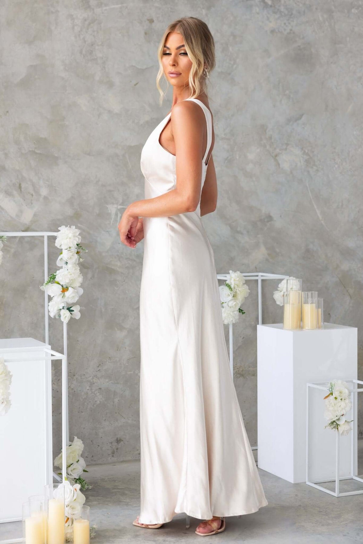 Elegant Darina Maxi Dress in satin, featuring a V-neckline and a flowing silhouette, showcased in a sophisticated setting.