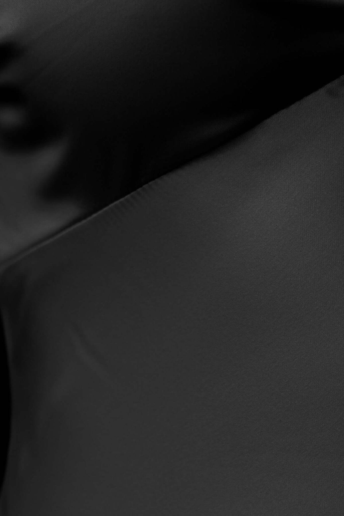Close-up of the sleek satin fabric of the black Hasina Maxi Dress, showcasing its luxurious texture and sheen.