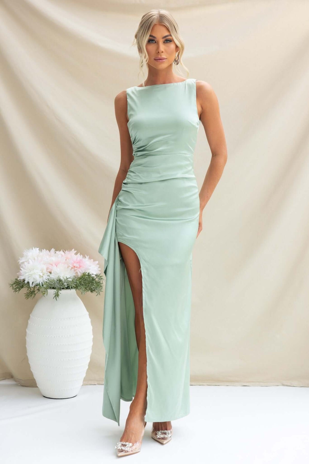 Kenzie Maxi Dress in mint green satin with high neckline and ruffle split skirt, modeled elegantly.