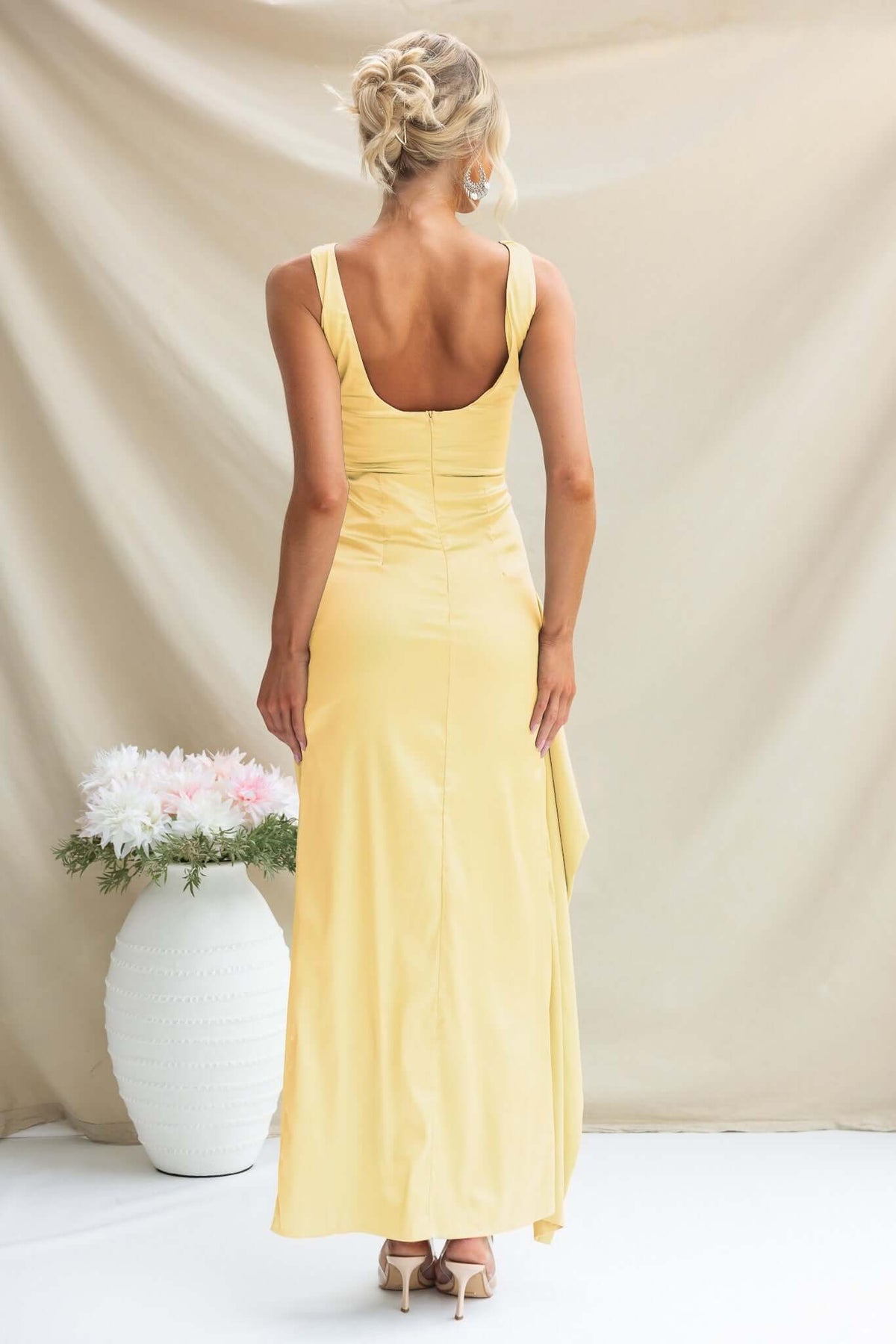 Back view of Kenzie Maxi Dress in yellow, featuring high neckline, fitted silhouette, and elegant high split.