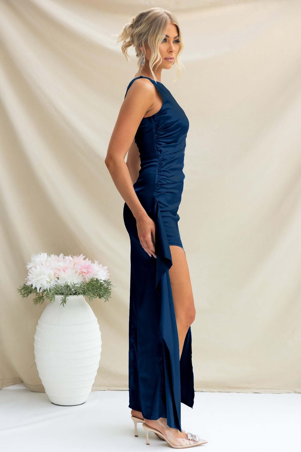 Navy Kenzie Maxi Dress featuring a high neckline, side split with ruffle, and satin material.