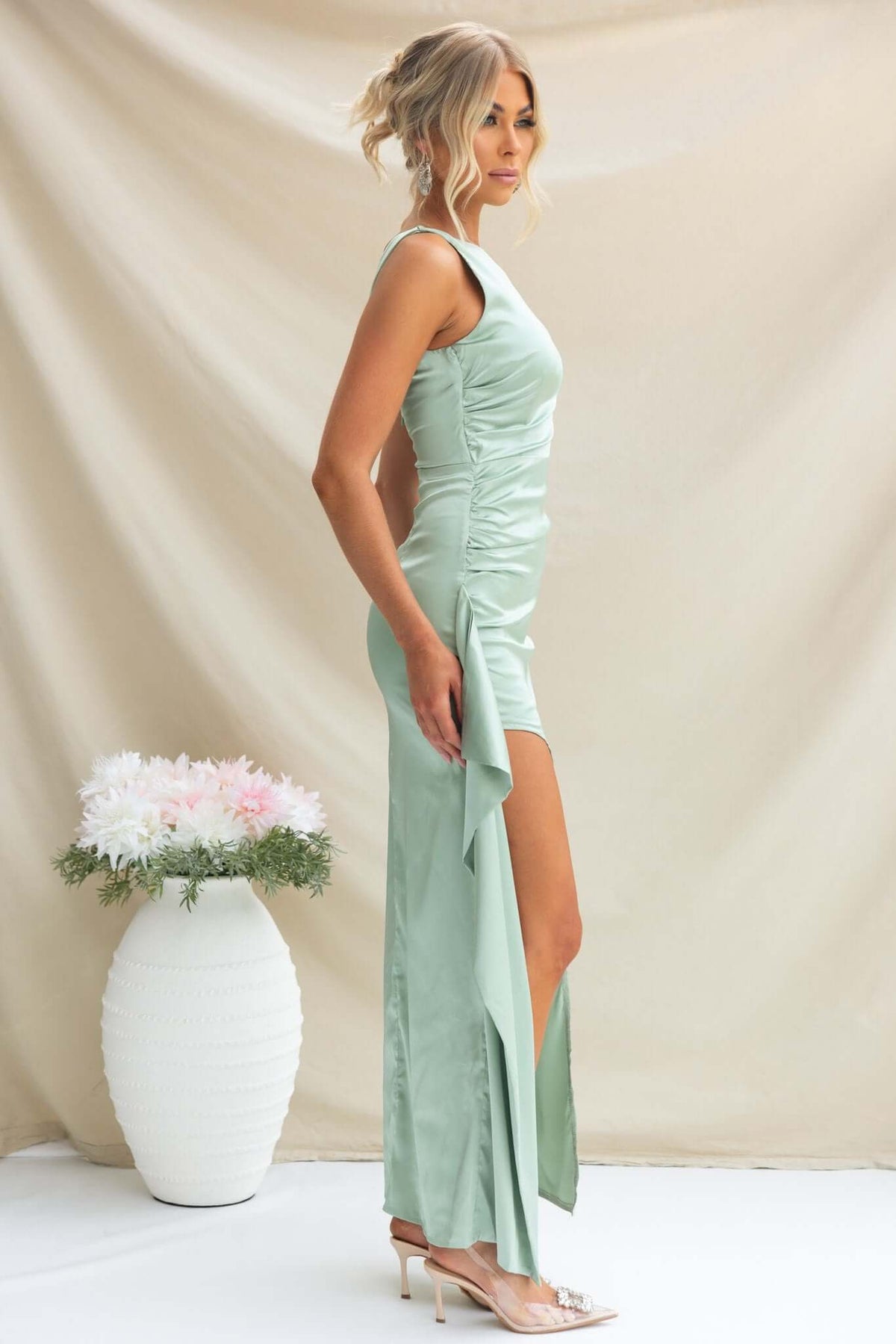 Model wearing a mint green Kenzie Maxi Dress with high side split and ruffle, showcasing a satin finish.
