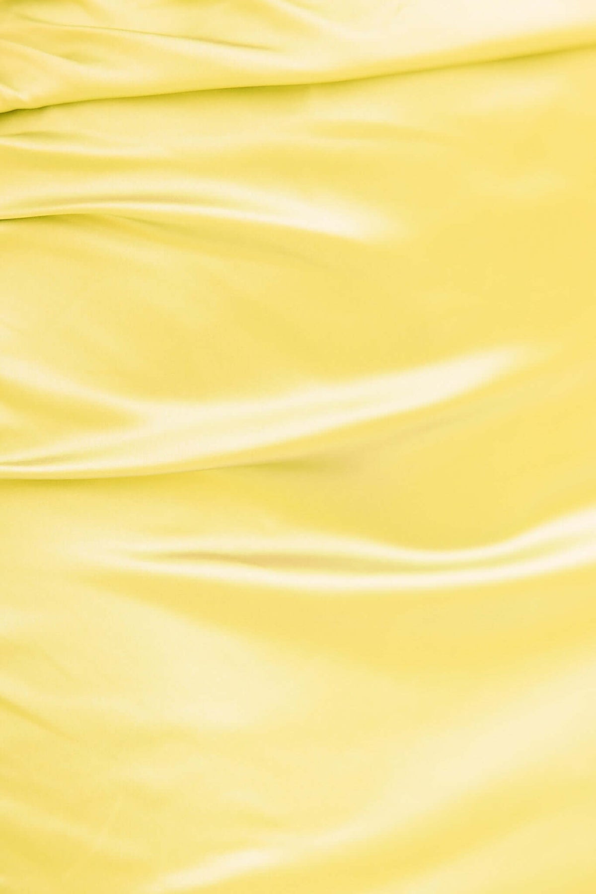 Close-up of smooth yellow satin fabric, showcasing texture and sheen, perfect for elegant maxi dresses.