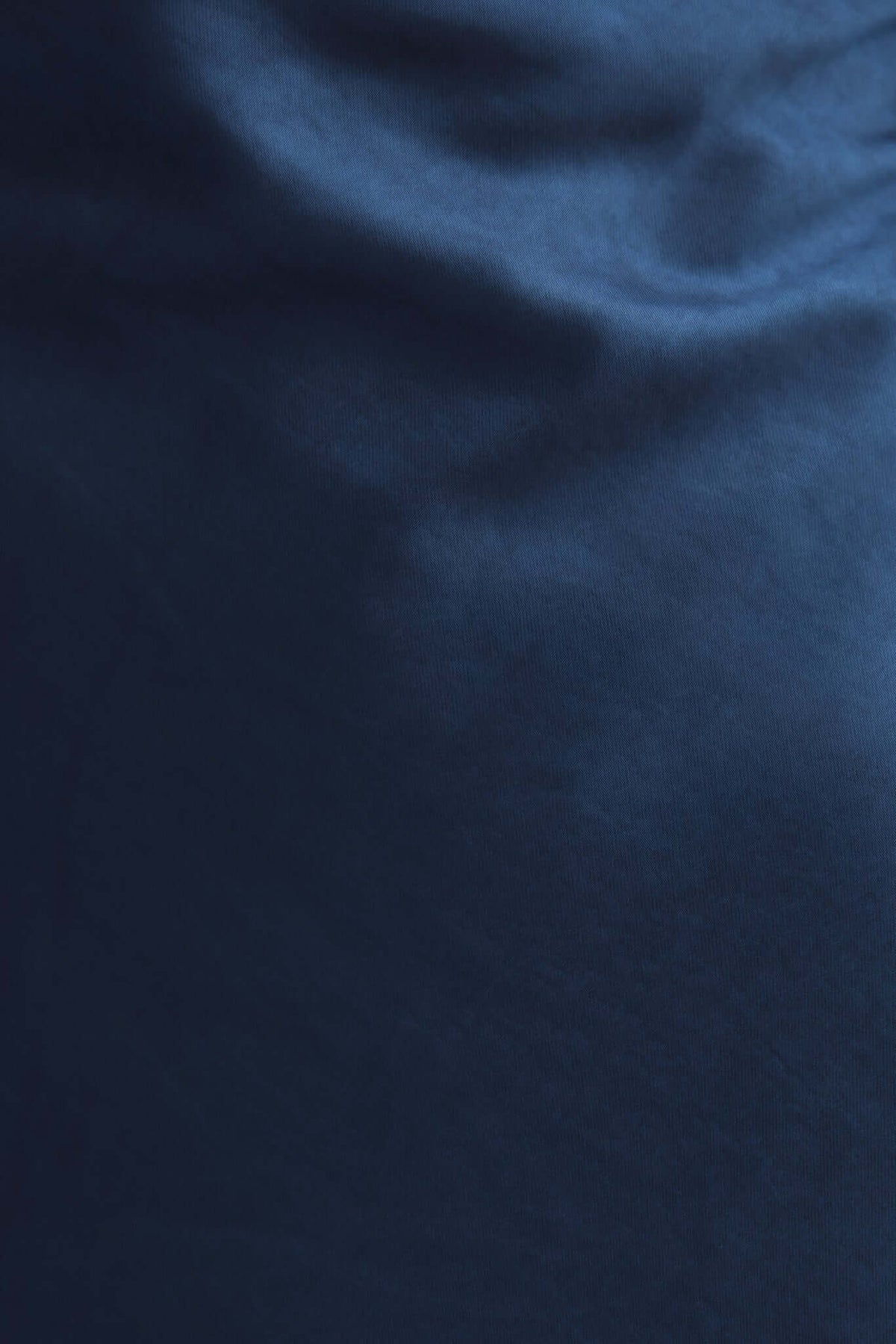 Close-up of navy satin fabric showcasing a smooth and luxurious texture, ideal for the Maeya Maxi Dress.