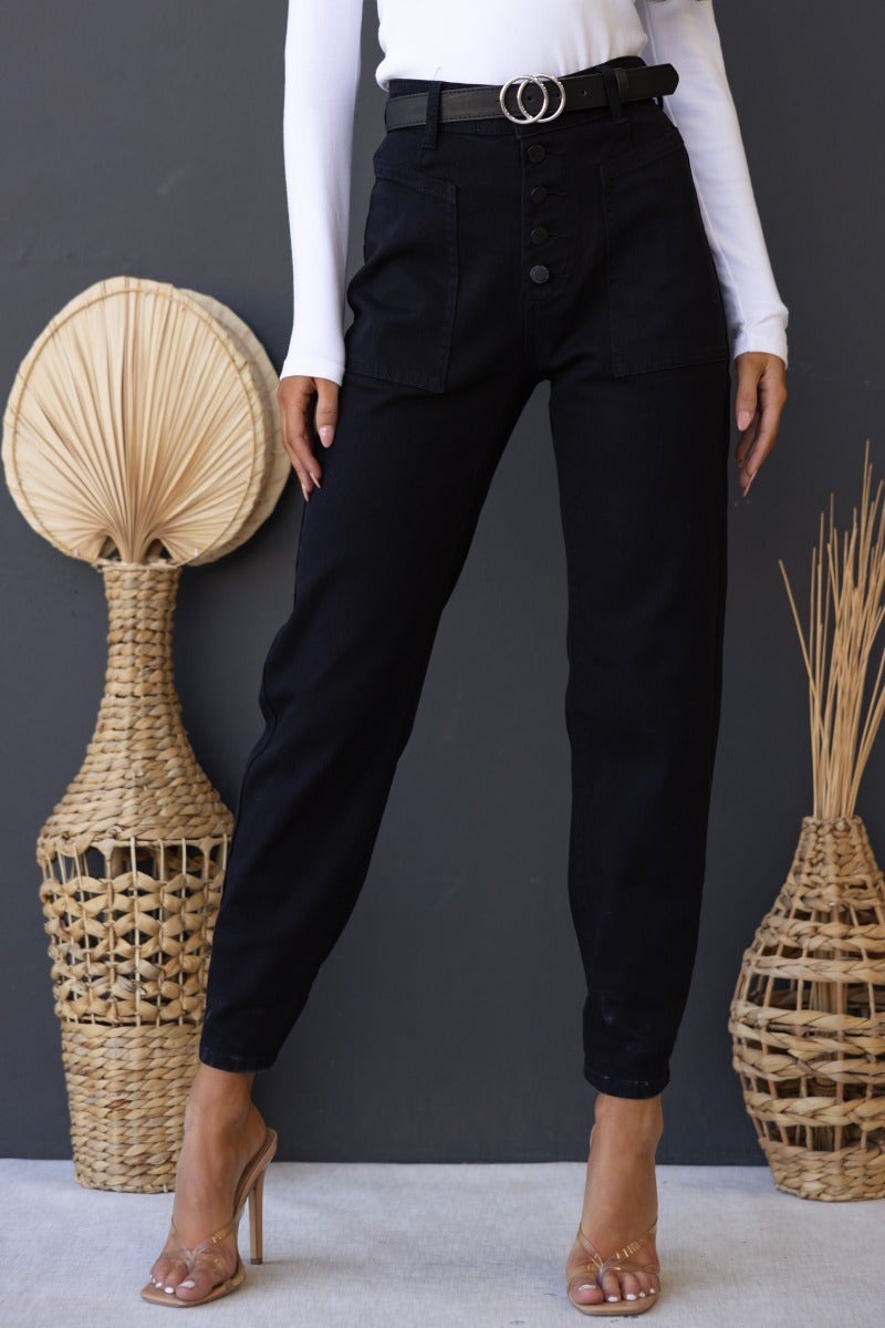 Model wearing Watson black denim jeans with mid-high waist fit, button front, and front-back pockets, styled with a white top.
