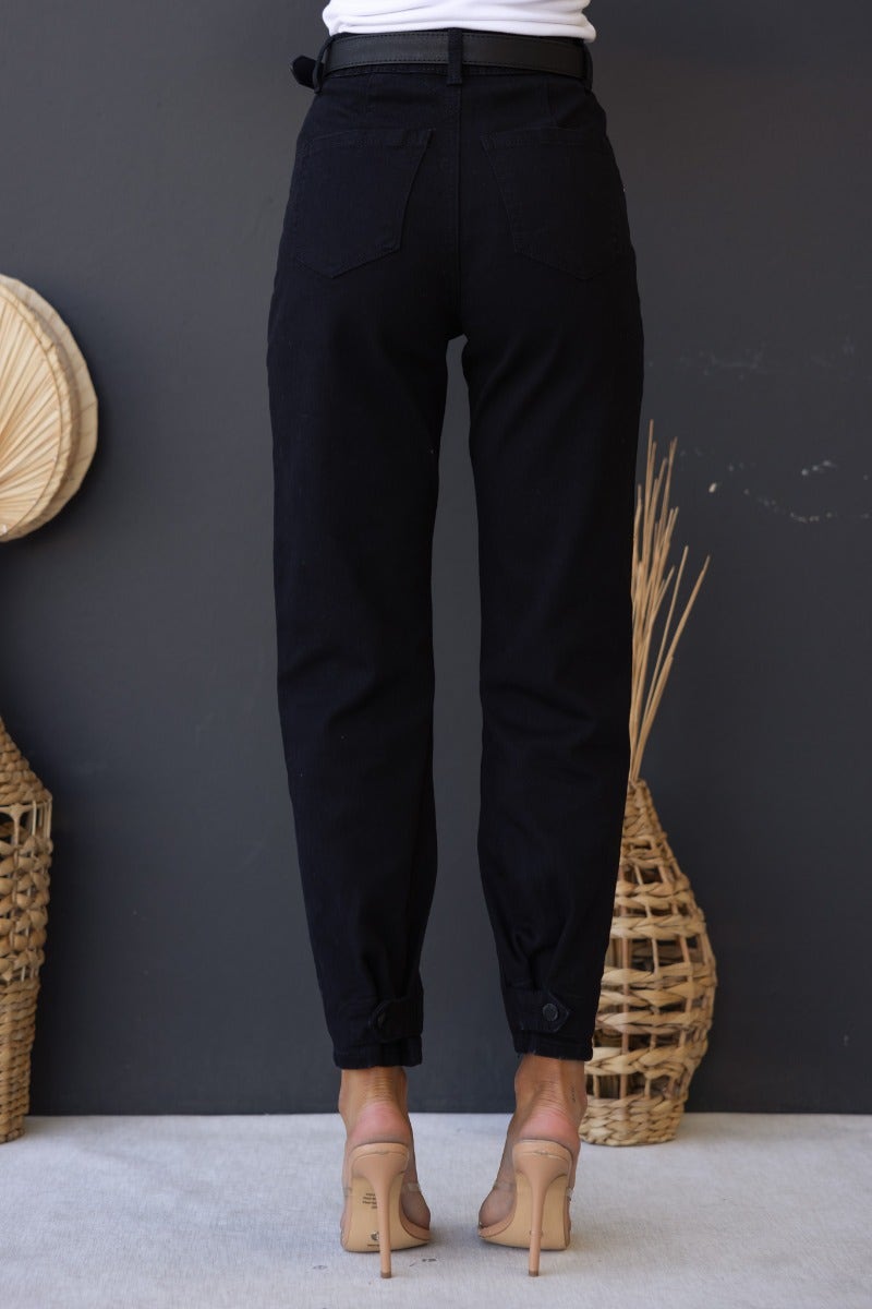 Back view of Watson Jeans in black denim, featuring a mid-high waist and button cuff at ankles.