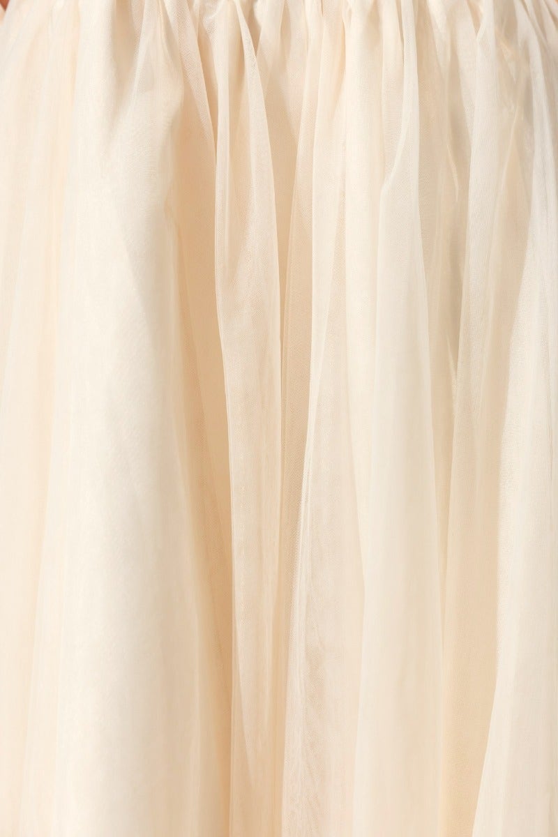 Close-up of Belle Maxi Dress tulle overlay in soft beige fabric showcasing its delicate texture.