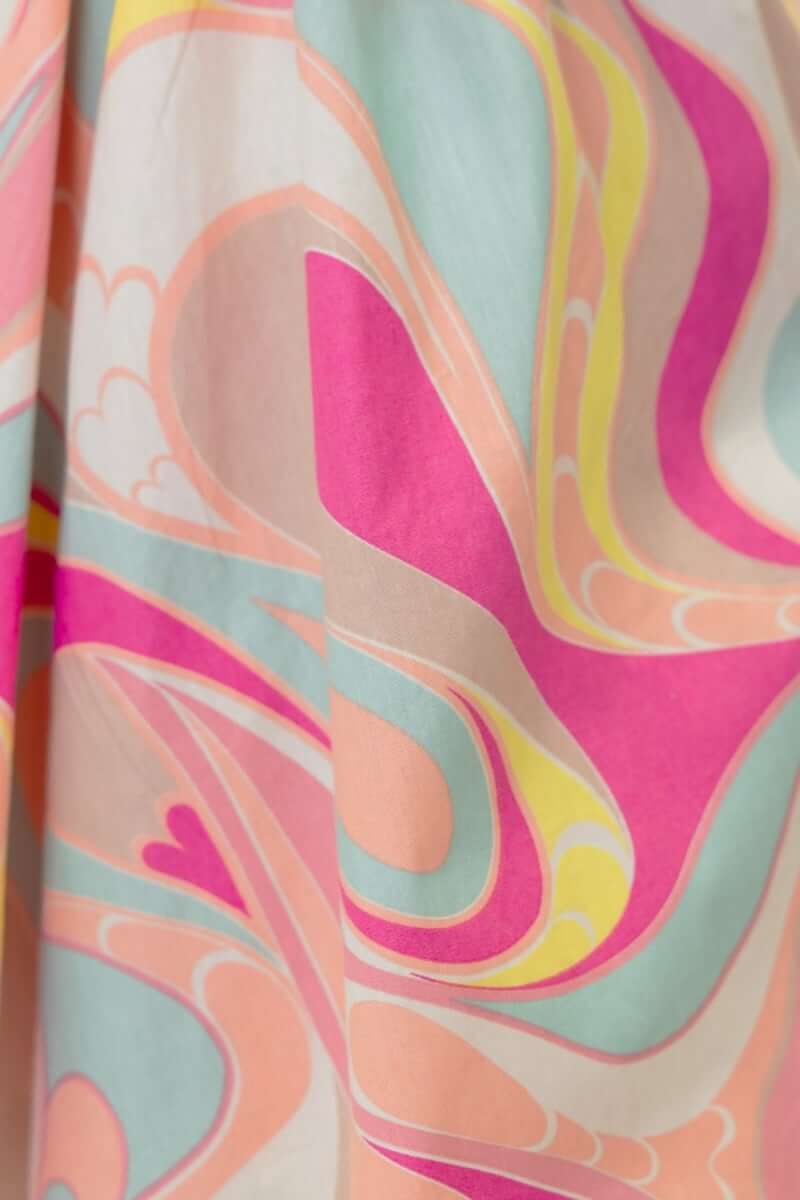 Close-up of colorful, swirling fabric pattern for the Tarnee Dress, featuring pink, peach, and mint hues.