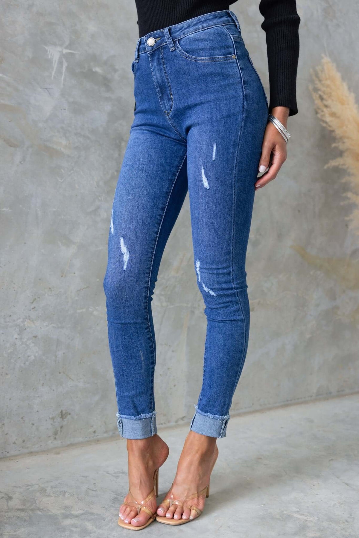 Lettie Jeans in distressed denim, mid-high waist fit, featuring front and back pockets, stylishly rolled cuffs.