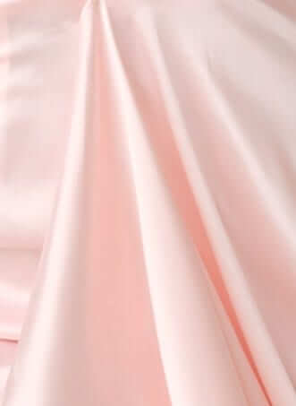 Close-up of soft, blush pink satin fabric, perfect for Qandice Midi Dress design.