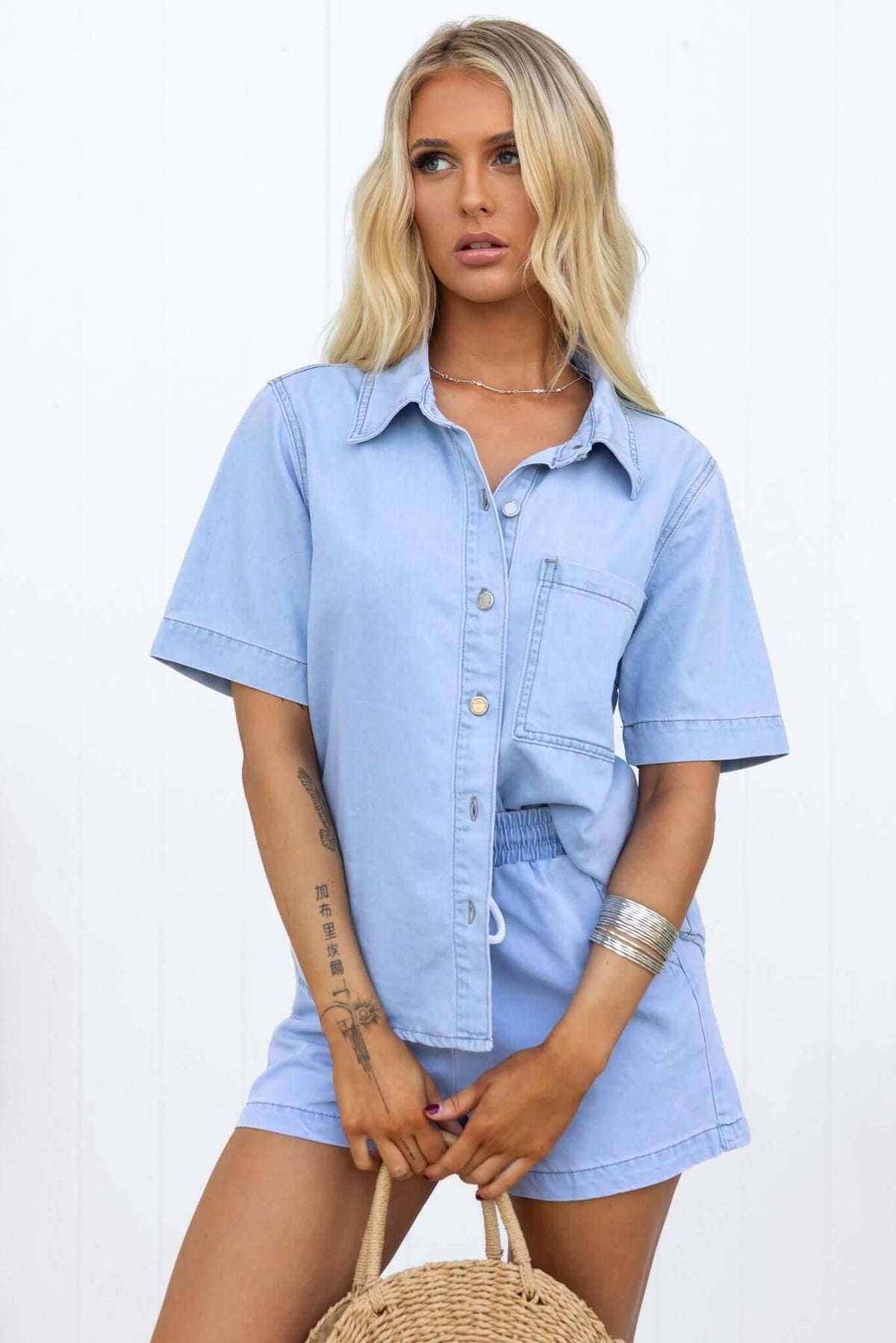 Winslow Shirt in chambray, featuring a button-down front and pocket, styled with matching shorts and accessories.