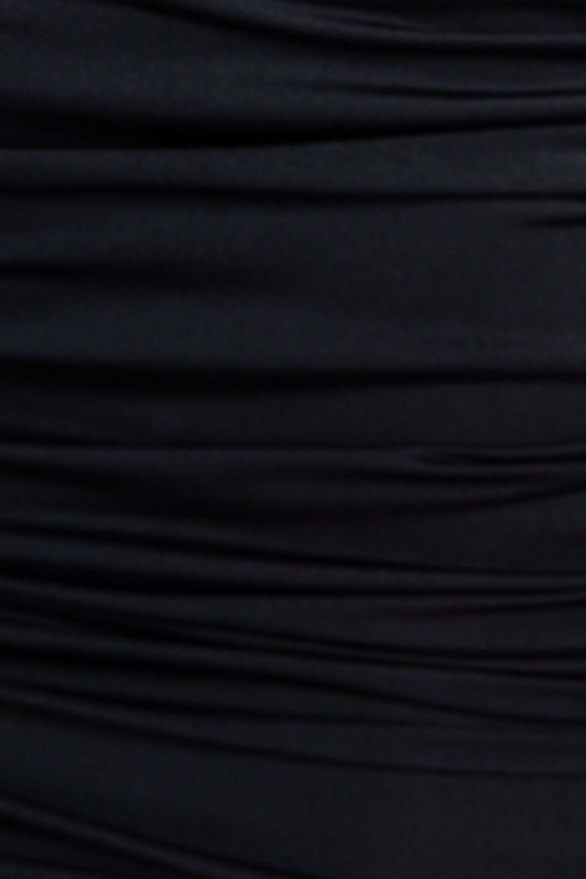 Close-up of gathered black fabric texture from the Paradise Dress, showcasing elegant ruching detail.
