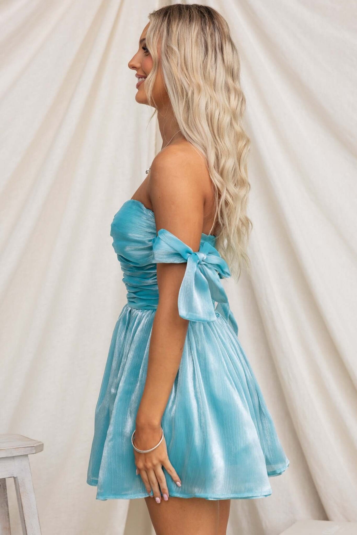 Irena Dress in teal with adjustable tie straps and tulle underskirt, showcased from the side.