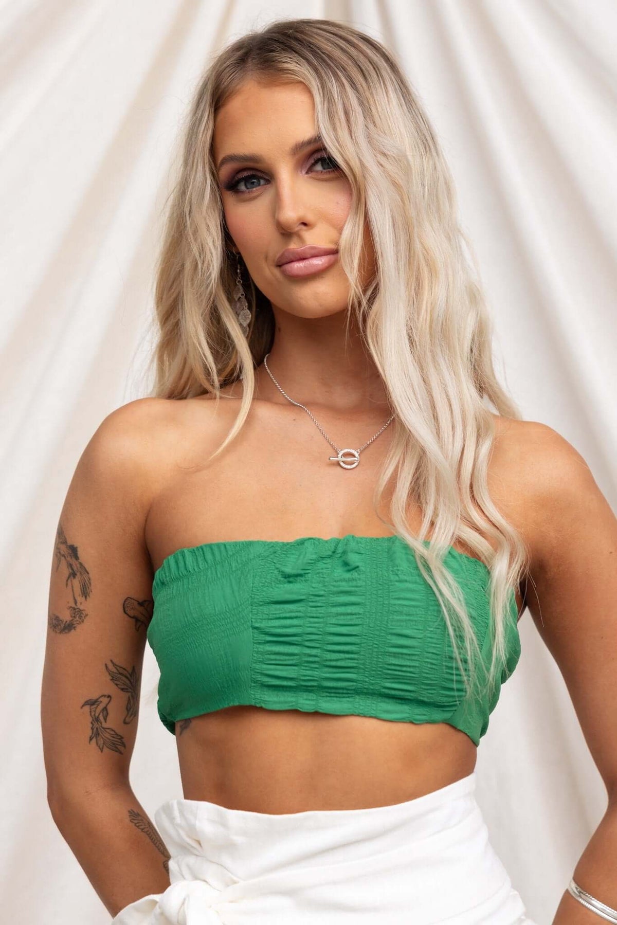 Model wearing the Omalie Top, a green textured strapless top with anti-slip bust and elastic back.