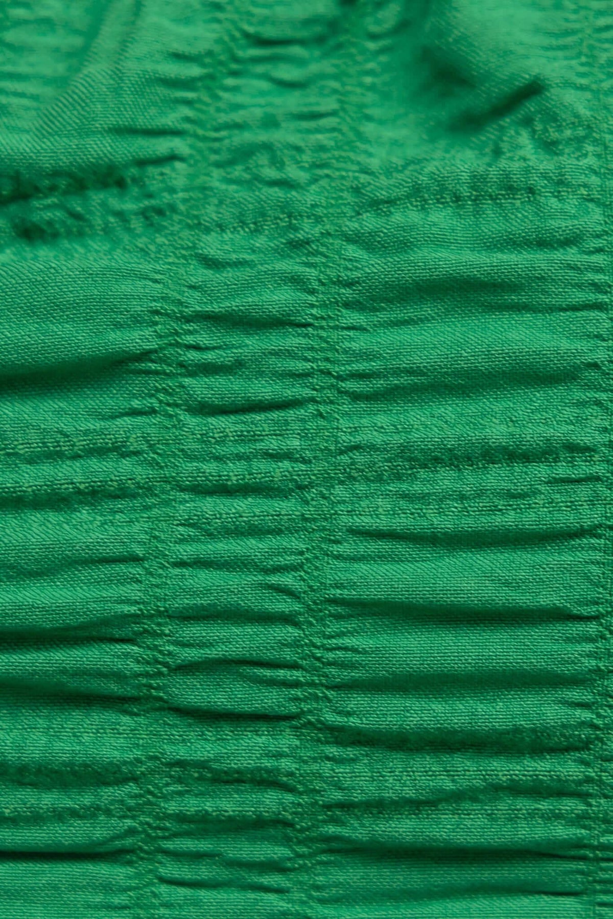 Close-up of textured green fabric with anti-slip design, showcasing gathered detail of the Omalie Top.