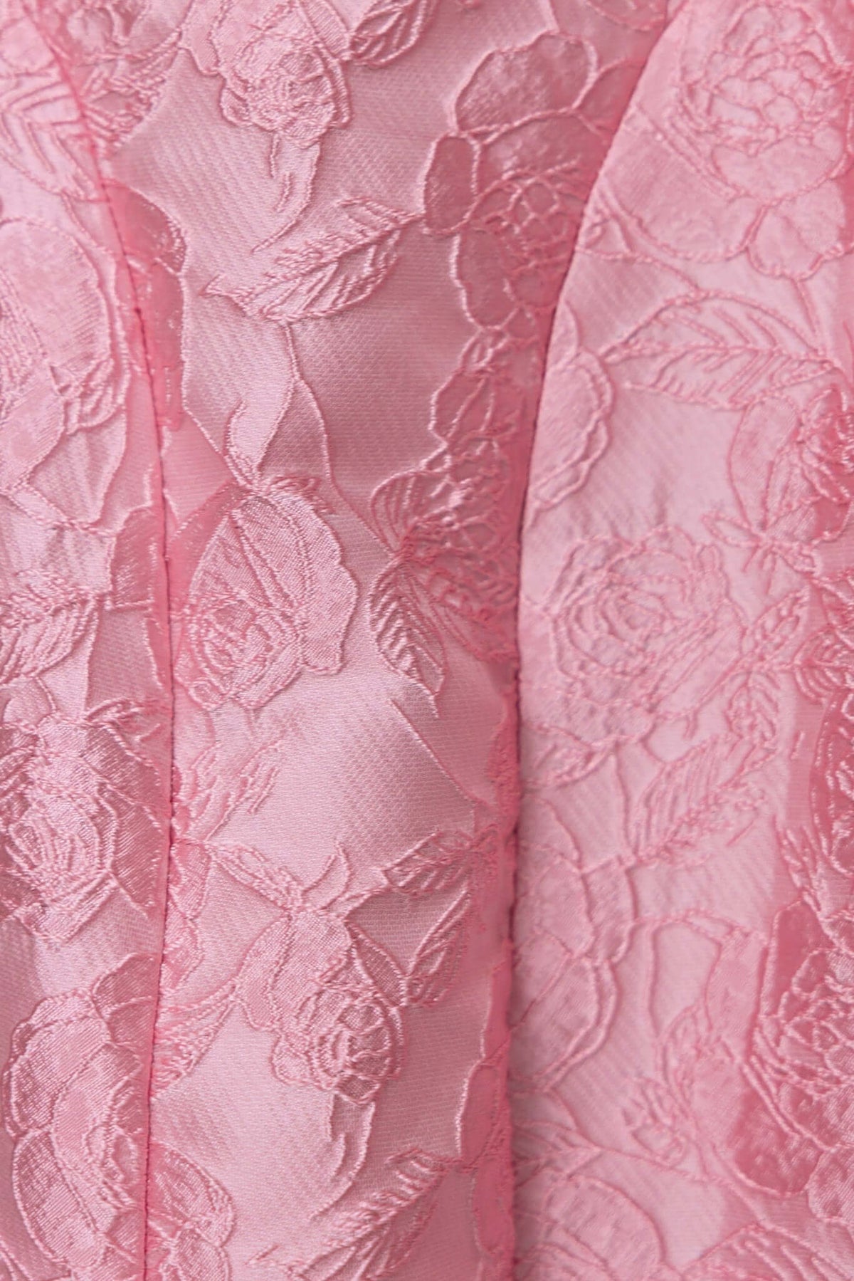 Close-up of textured pink fabric with floral design, highlighting the delicate embroidery of the Jadyne Midi Dress.