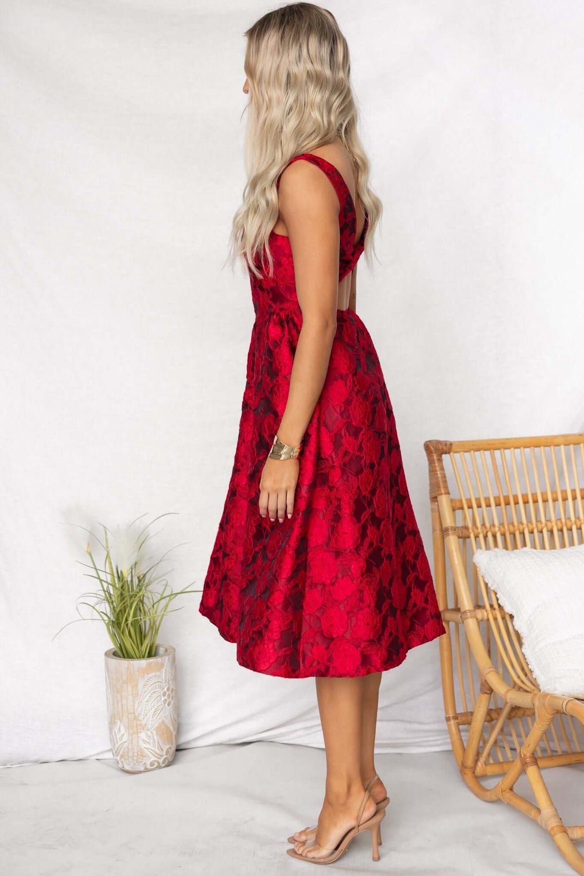 Red midi dress with textured floral design, showcasing a flattering fit and elegant silhouette, worn by a model.