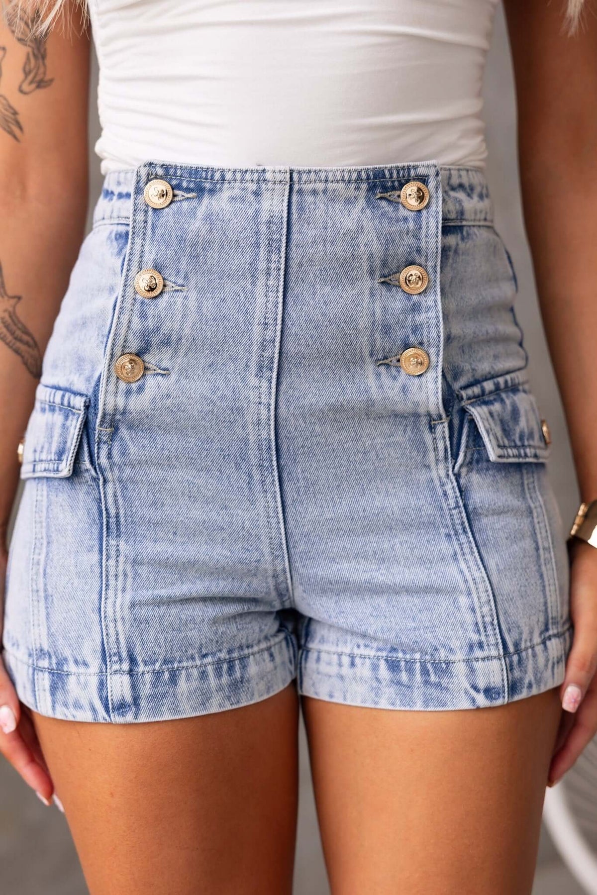 Osment Denim Shorts featuring a mid-high waist, button-up front, and side pockets, in light blue denim.