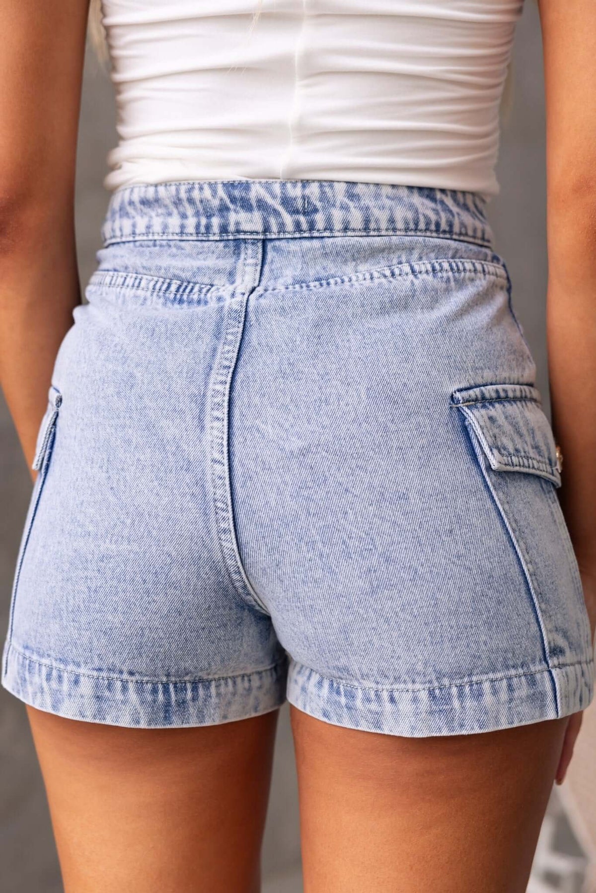 Osment Denim Shorts in light blue, showcasing a mid-high waist fit and side pockets from the back view.