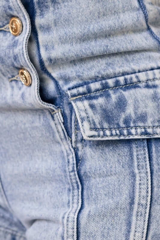 Close-up of Osment Denim Shorts showing mid-high waist, button-up front, and side pocket details.