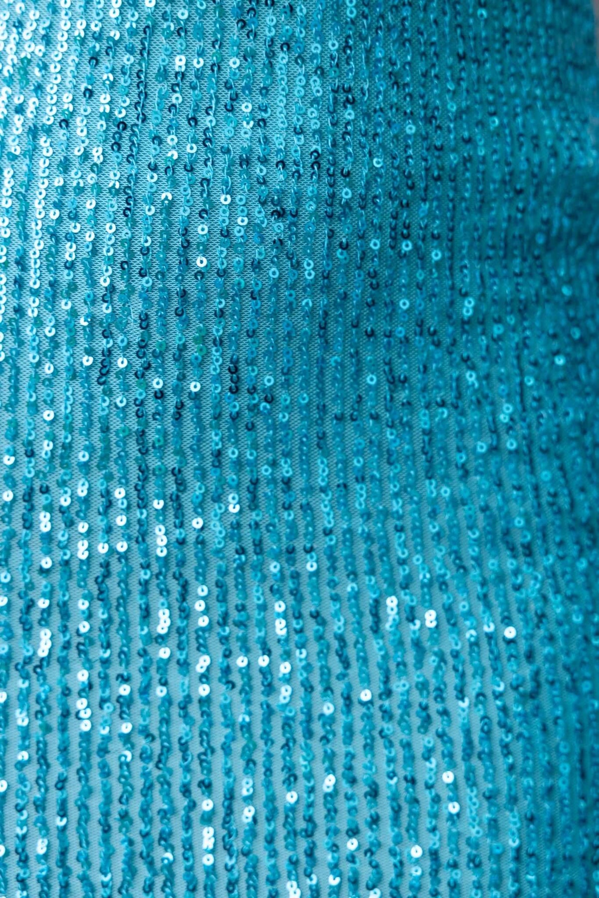 Close-up of blue sequin fabric highlighting shimmer and texture of the Made You Look Dress.