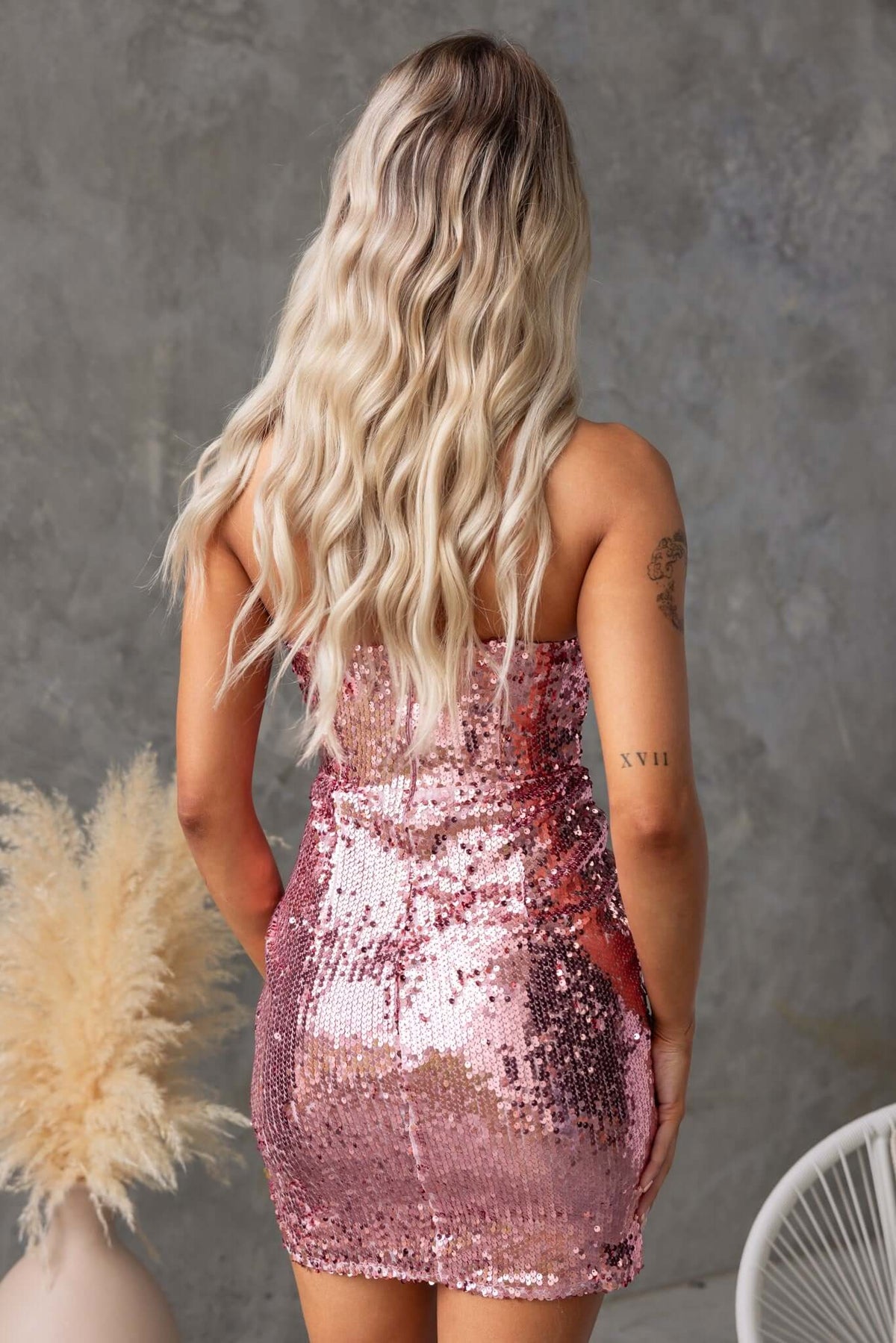 Back view of Qordelia sequin dress, showcasing the strapless design, padded bust, and shimmering pink sequins.