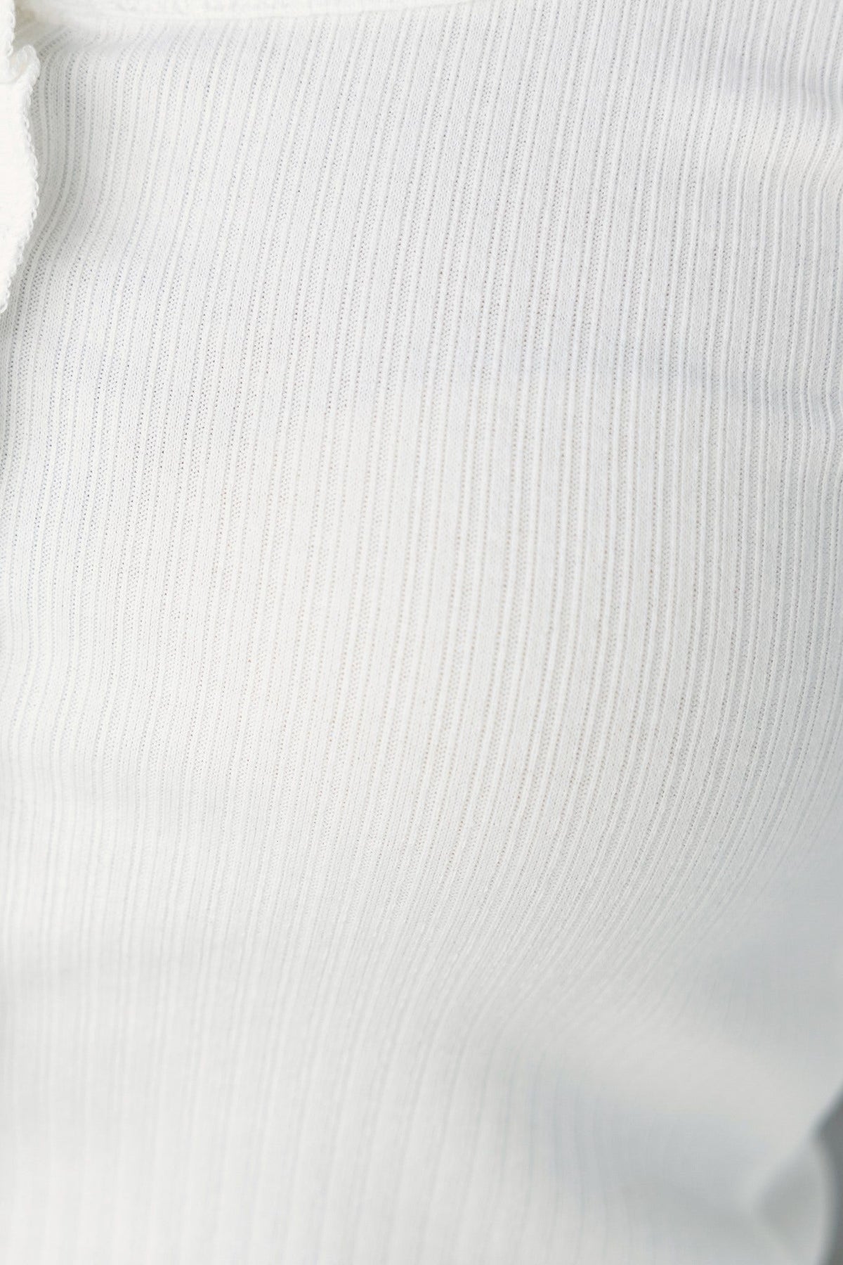 Close-up of Seona Top in white, showcasing ribbed texture and stretchy material.