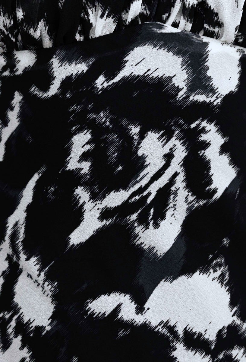 Close-up of black and white floral pattern fabric, showcasing the gathered texture of the Freyda Maxi Dress.
