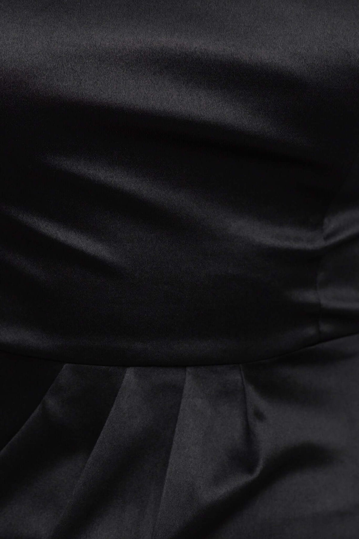 Close-up of black satin fabric, showcasing the smooth texture and pleating of the Rommey Maxi Dress.