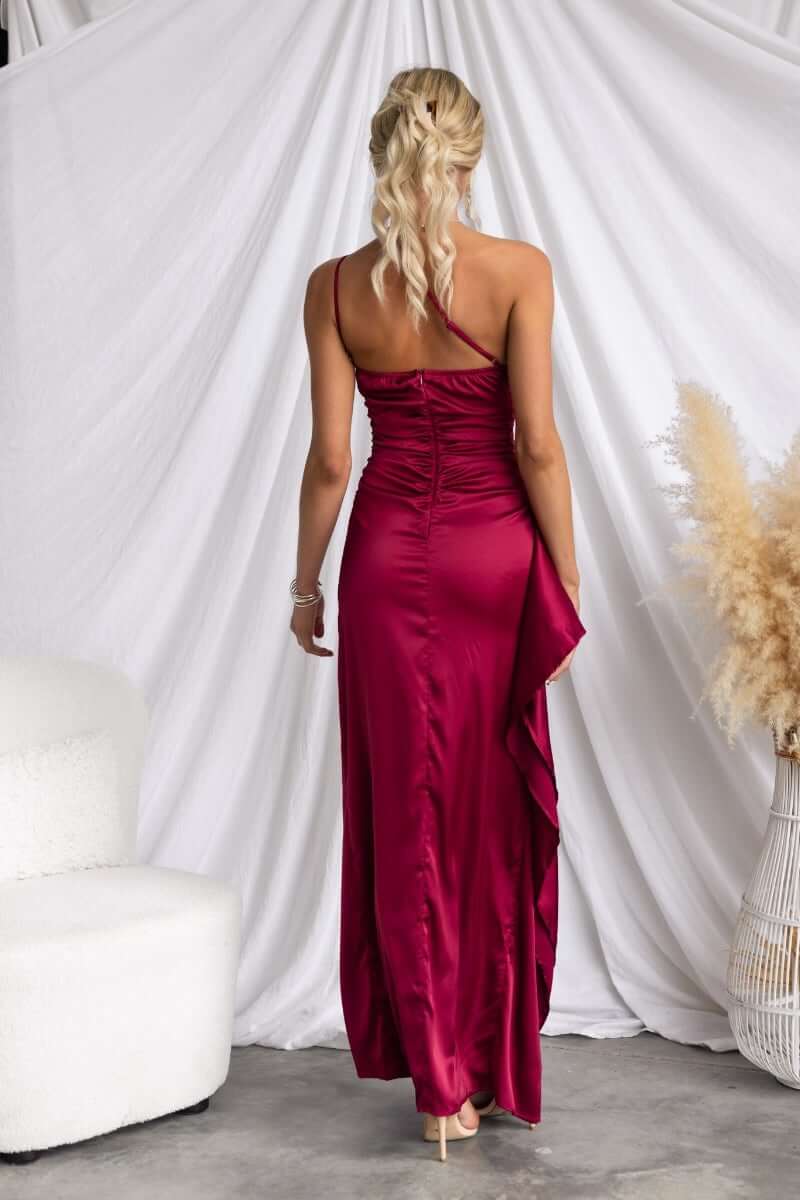 Back view of the Dimmi Maxi Dress in satin, featuring a one-shoulder design and asymmetrical hemline with ruffle trim.