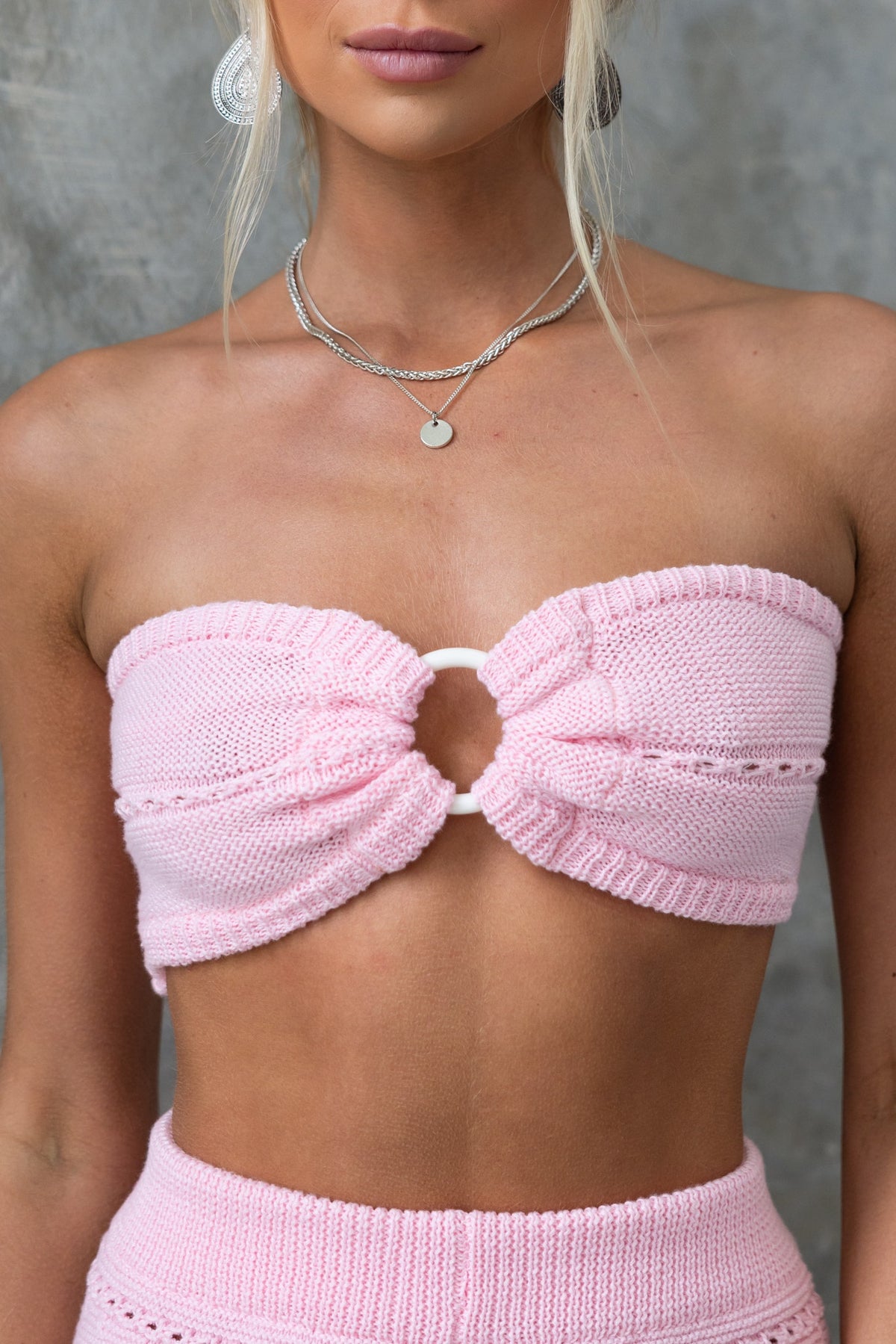 Front view of the Pearla Top, a strapless pink knitted top with a ring detail at the bust, ideal for summer outfits.