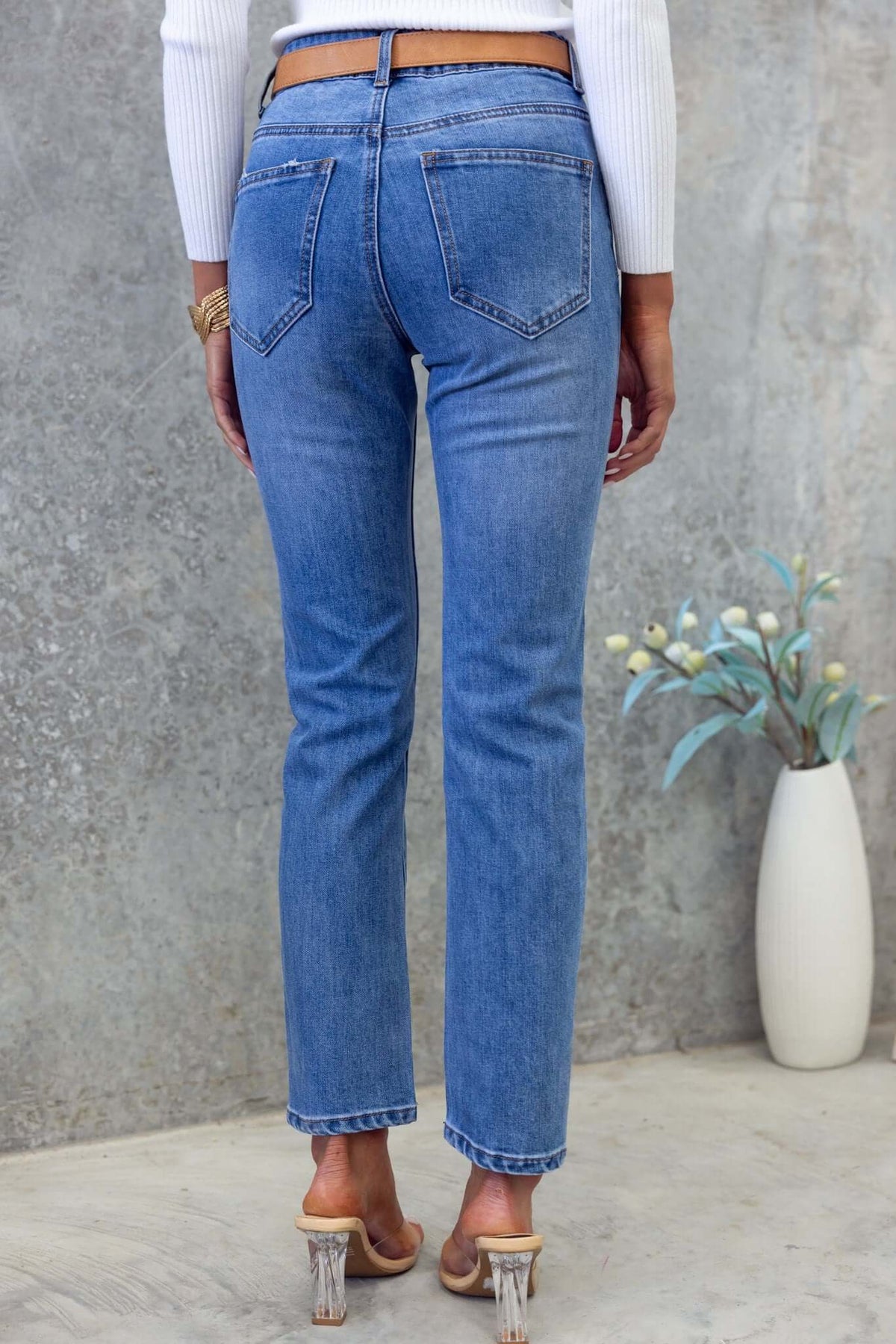 Back view of Selma Jeans featuring a mid-high waist, straight leg fit, and pockets, styled with a simple white top.