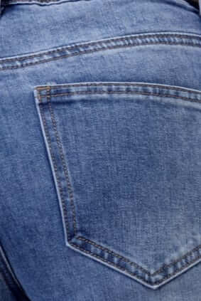 Close-up of the back pocket on Selma Jeans in light blue denim with a casual style.
