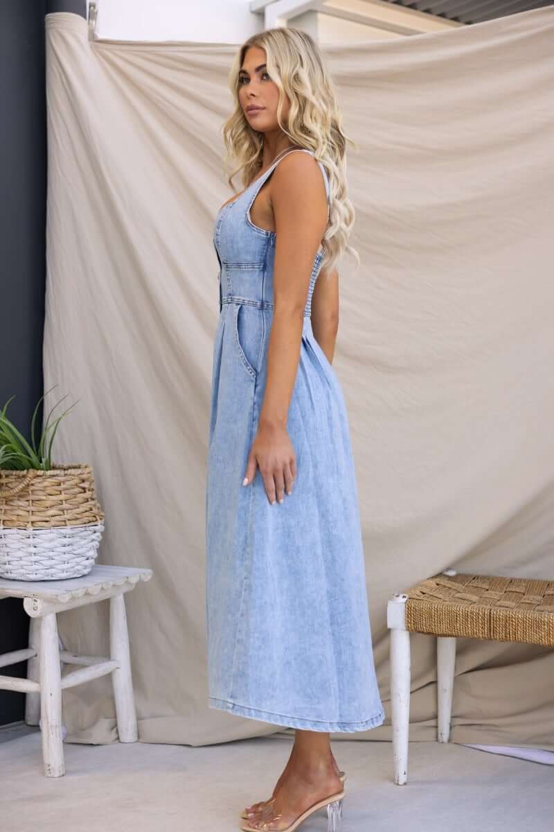 Side view of Tailey Denim Midi Dress featuring faux buttons, elastic back, and side pockets, perfect for stylish summer outings.
