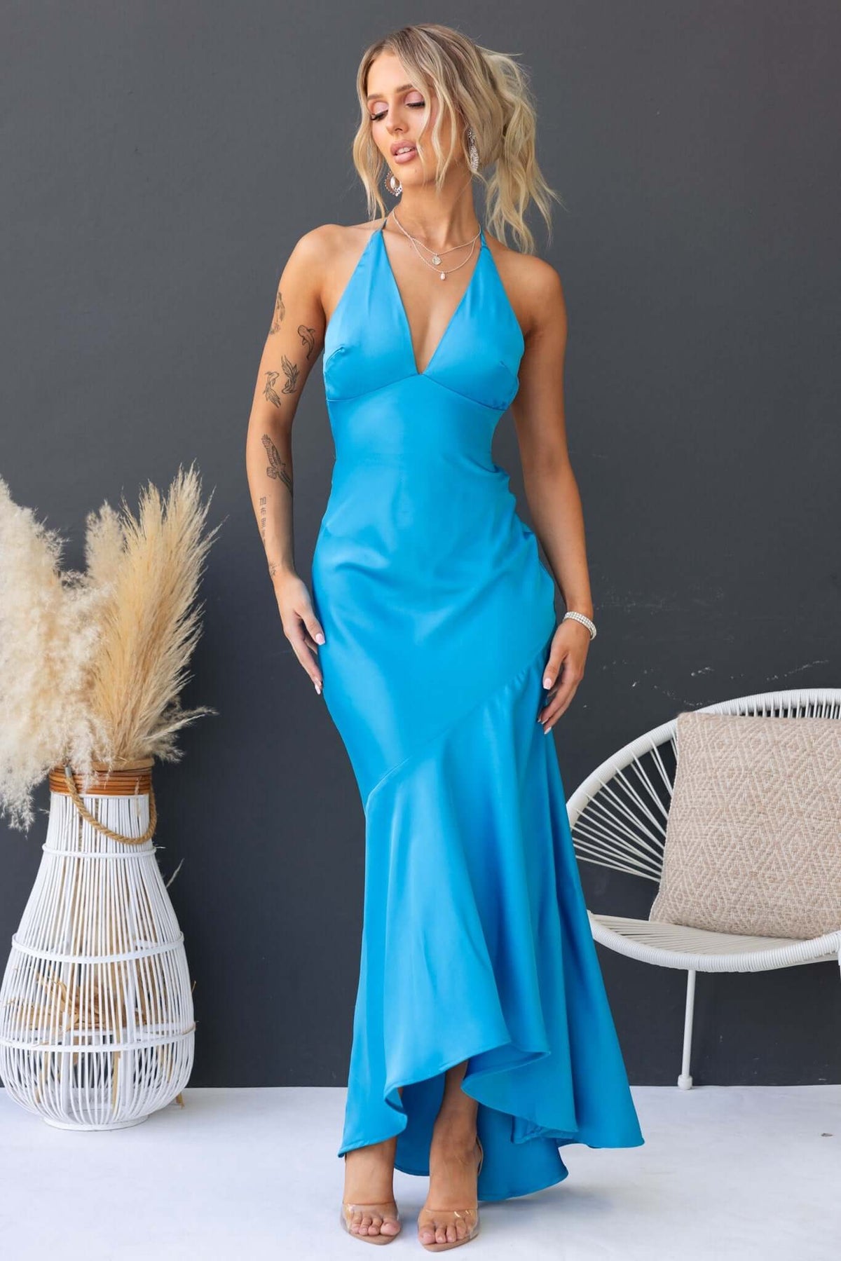 Woman in a blue Ramona Maxi Dress featuring a halter neckline and a flowing skirt, styled with minimal accessories.